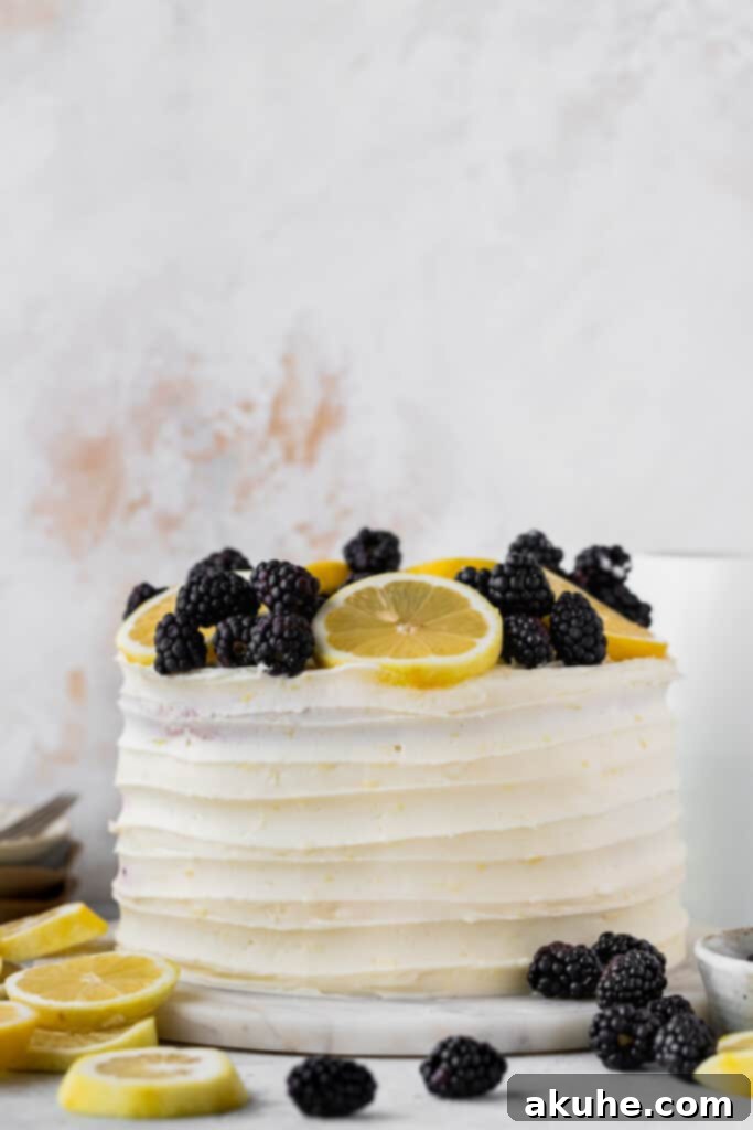 Zesty Lemon Blackberry Delight 12 A beautifully decorated Lemon Blackberry Cake with fresh lemons and blackberries on a marble serving board.