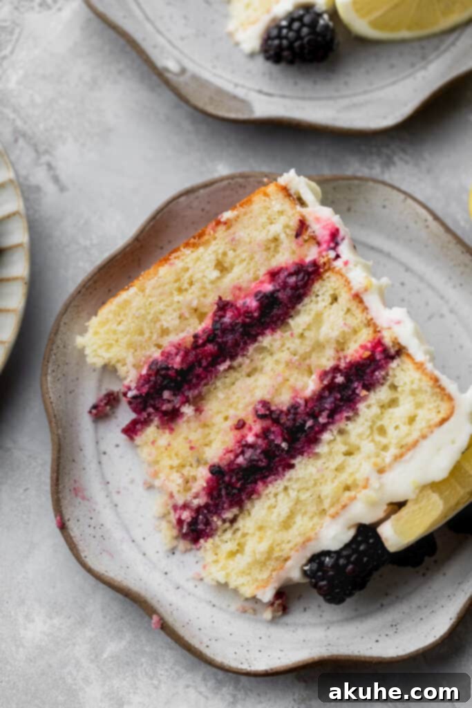 Zesty Lemon Blackberry Delight 14 A single slice of Lemon Blackberry Cake on a white plate, showcasing its layers.
