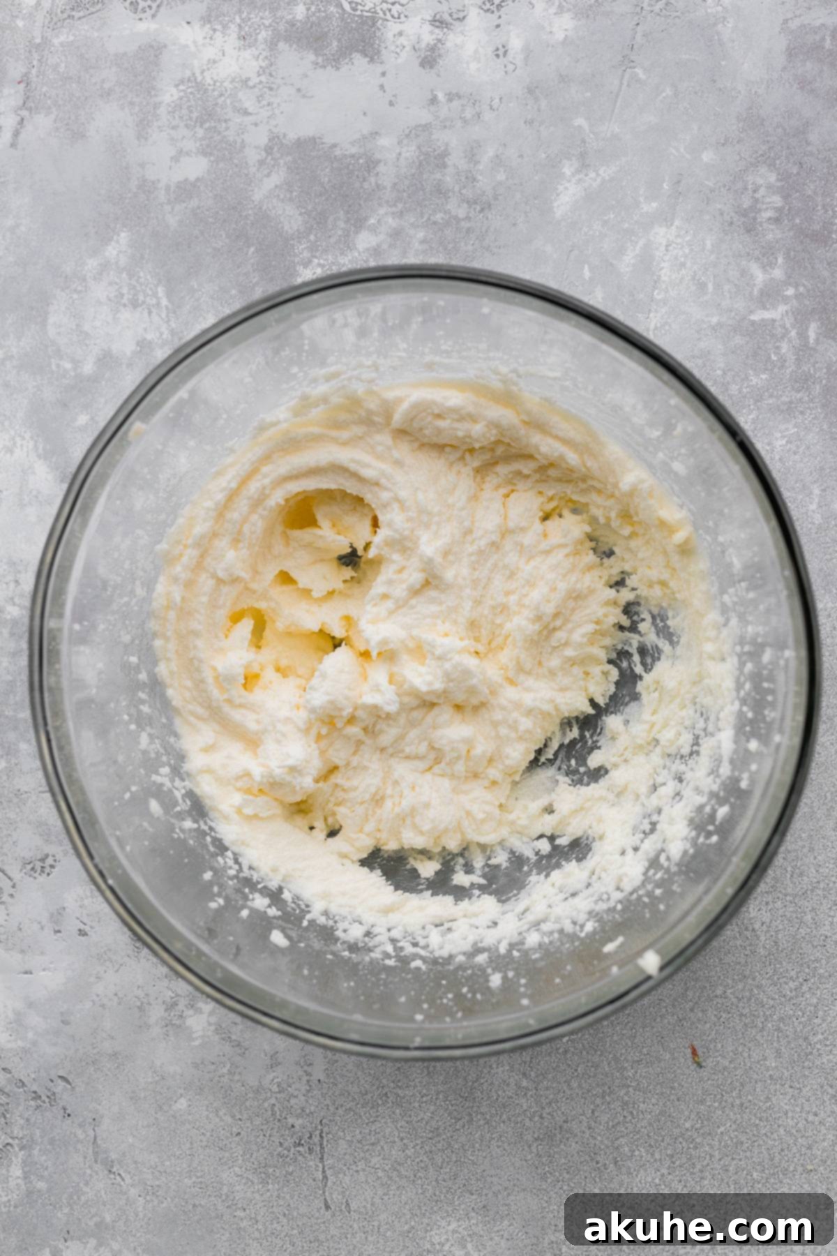 Zesty Lemon Blackberry Delight 4 Close-up of beaten butter, oil, and sugar in a glass mixing bowl, light and creamy.