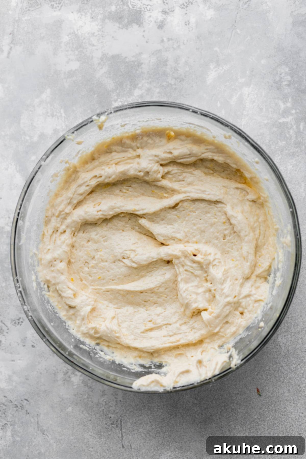 Zesty Lemon Blackberry Delight 5 Lemon cake batter in a clear glass bowl, showing its smooth, pale yellow texture.