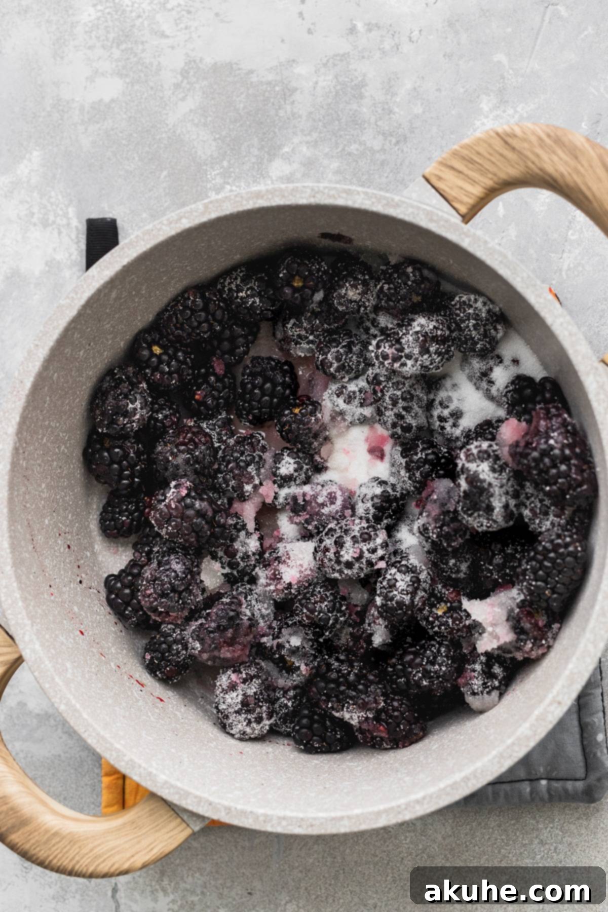Zesty Lemon Blackberry Delight 7 Blackberries and sugar simmering in a pot on the stovetop for homemade jam.