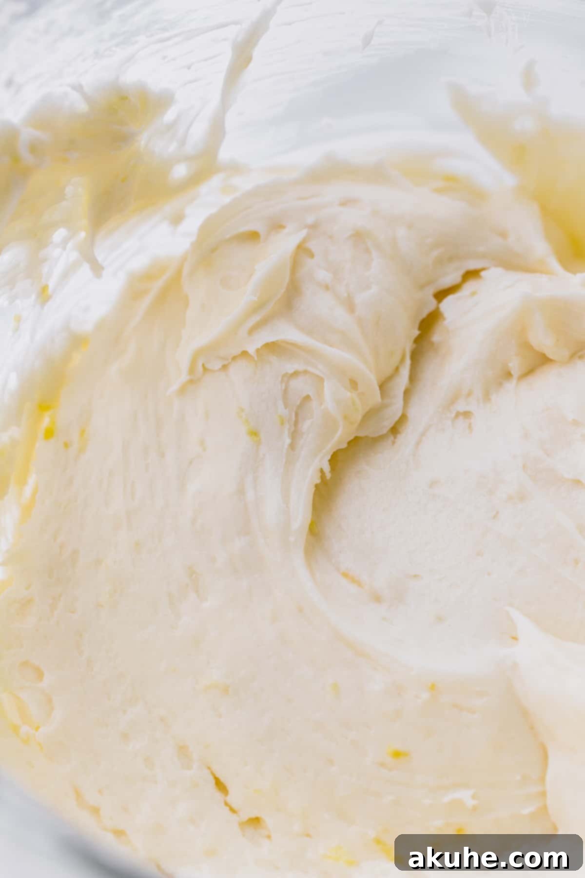 Zesty Lemon Blackberry Delight 9 Creamy lemon cream cheese frosting in a glass mixing bowl, ready for cake assembly.
