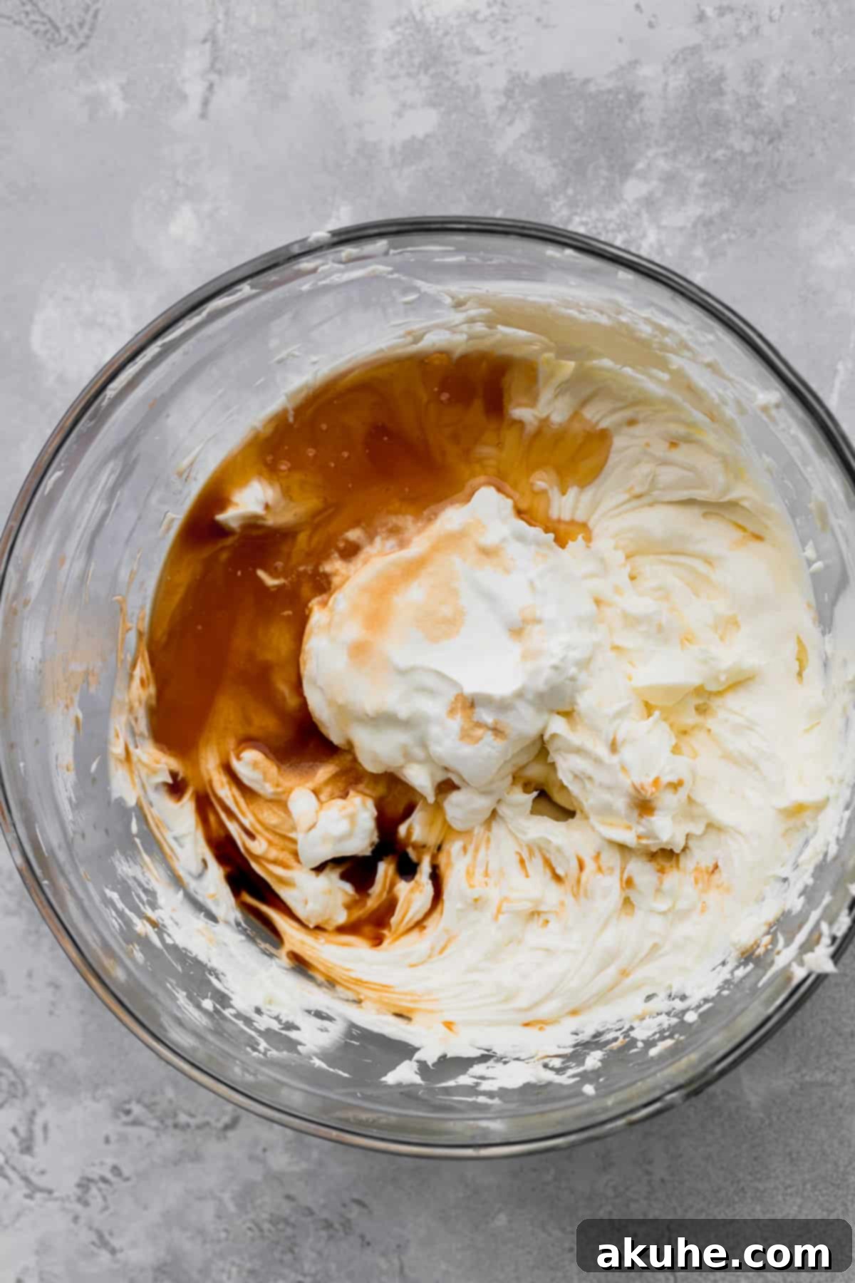 Honey, sour cream, and vanilla extract being added to the cream cheese and sugar mixture.
