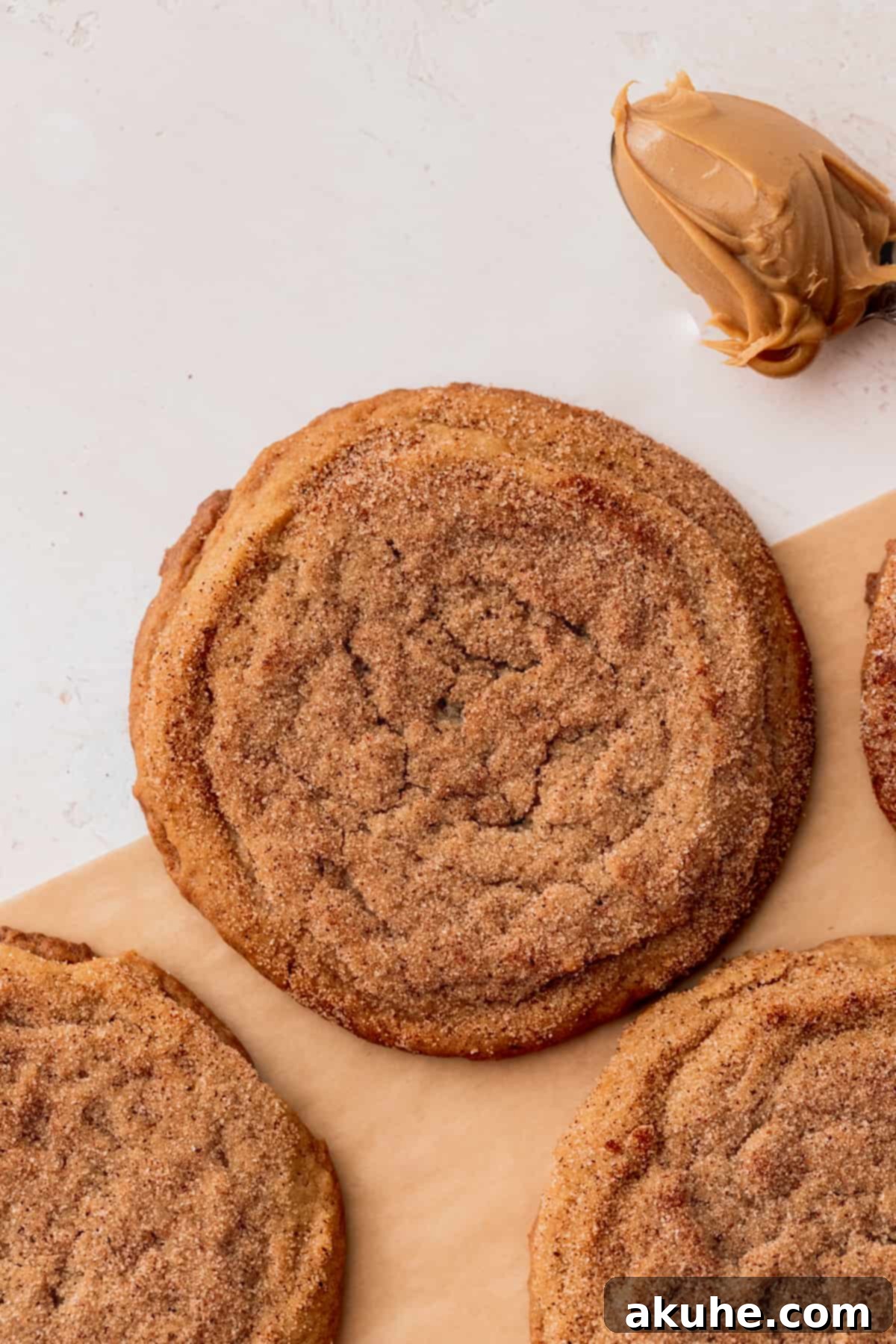 Snickerdoodle Peanut Butter Bliss 2 Chewy peanut butter cookie dipped in cinnamon sugar on parchment paper.