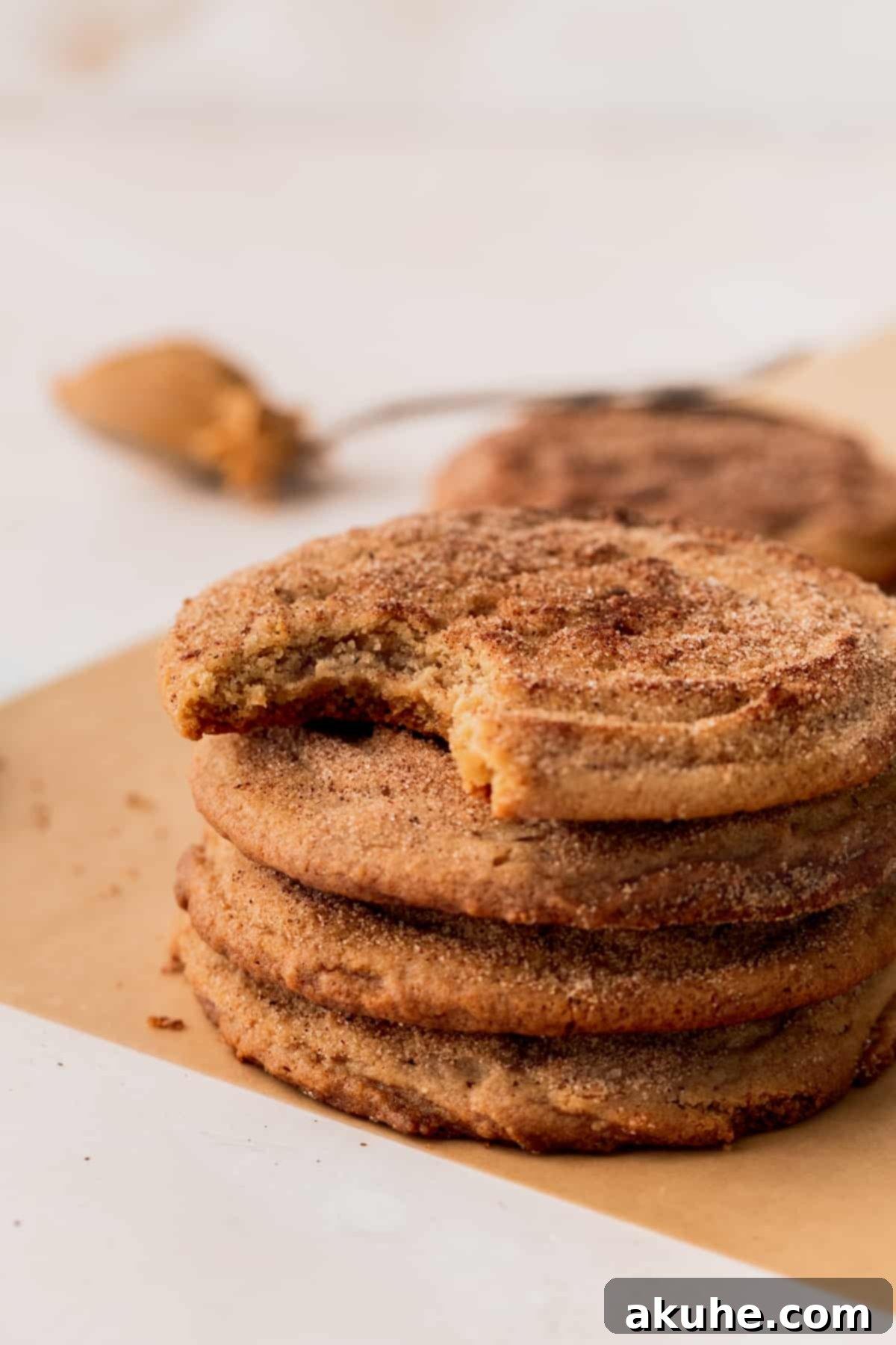 Snickerdoodle Peanut Butter Bliss 10 A stack of snickerdoodle peanut butter cookies on parchment paper.