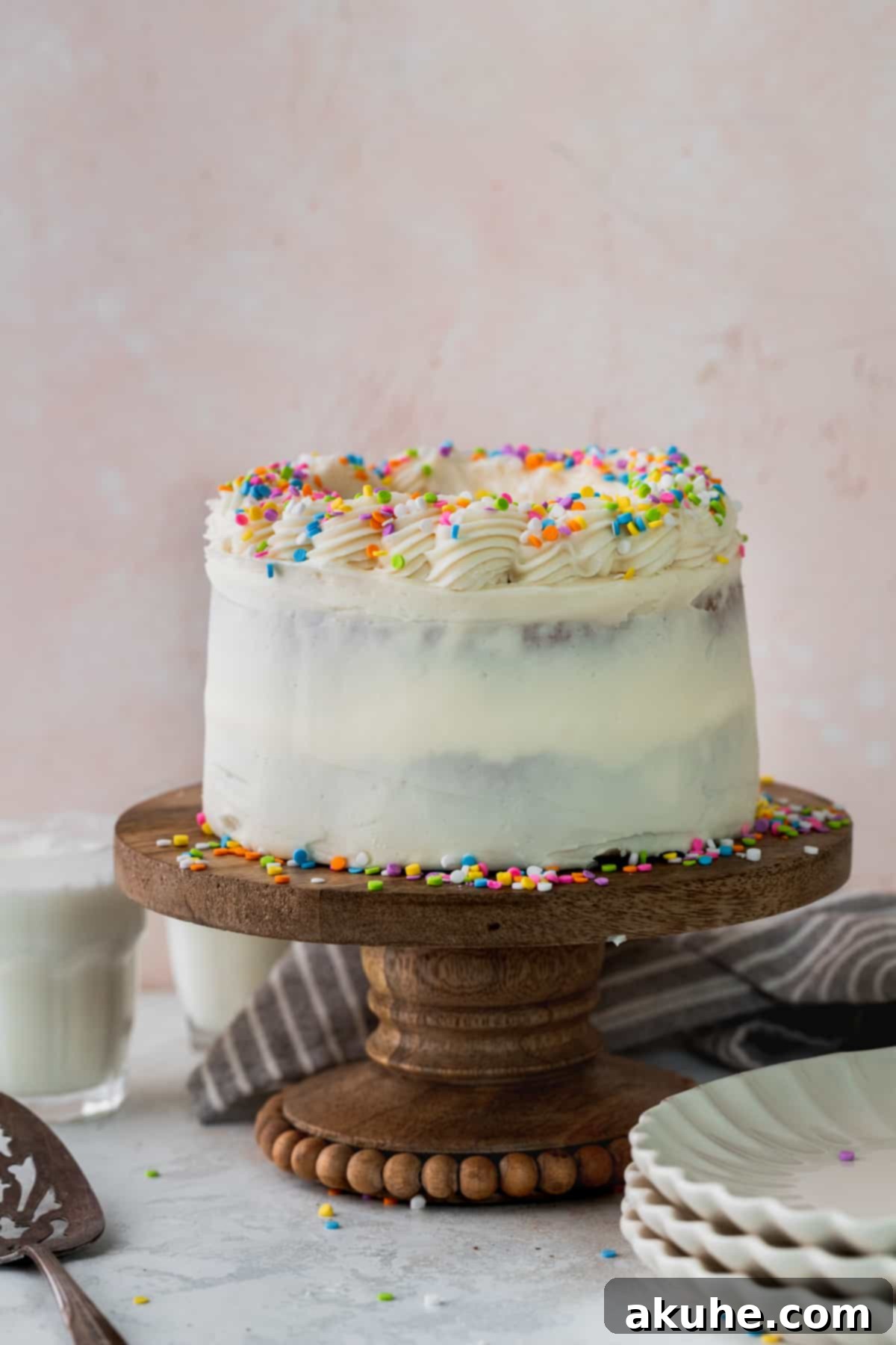 Vanilla Bean Mini Cakes 3 A beautifully frosted mini vanilla cake presented on a elegant cake stand, ready for serving.