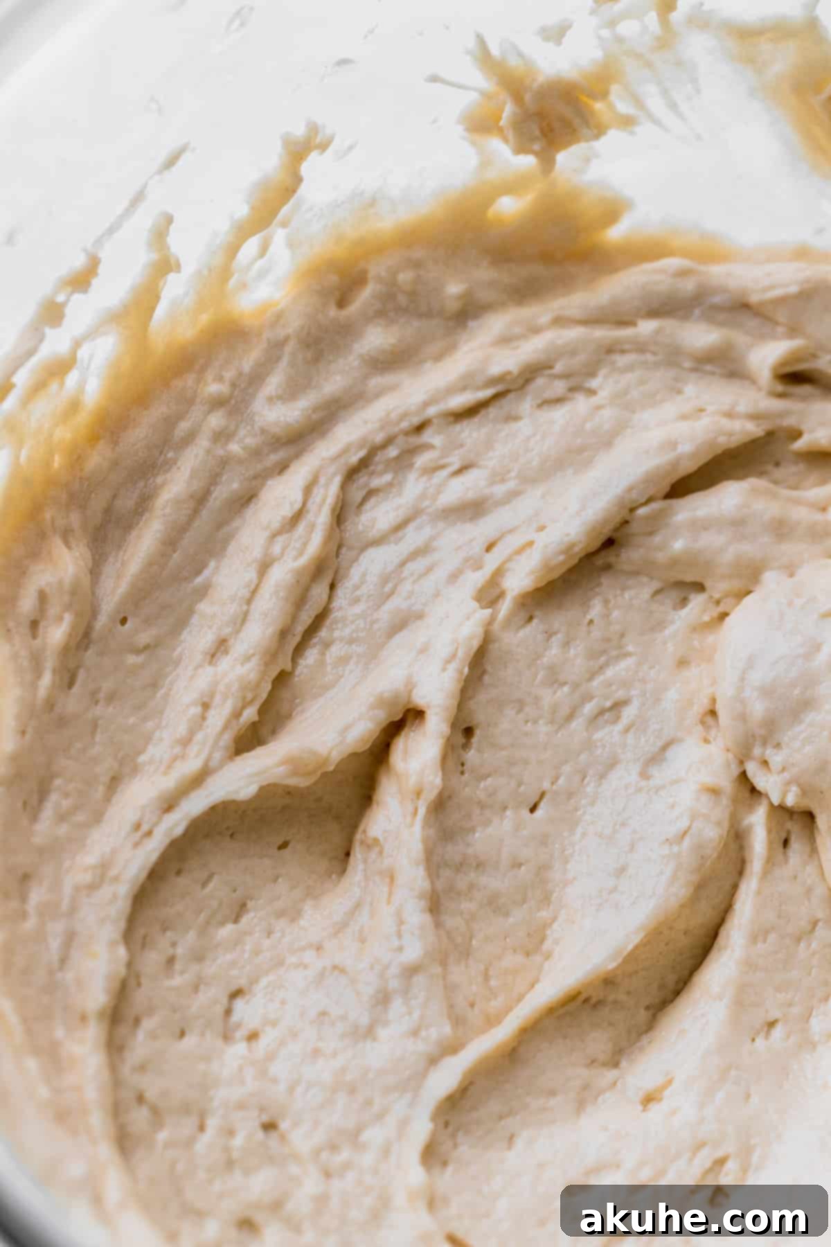 Vanilla Bean Mini Cakes 6 Smooth vanilla cake batter glistening in a glass mixing bowl, ready for baking.