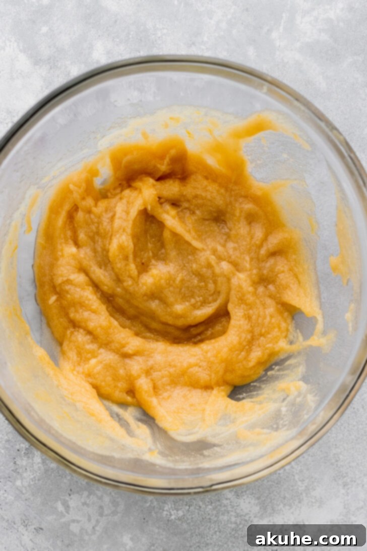 Wet ingredients including melted butter, sugar, lemon zest, and eggs, mixed in a large glass bowl.