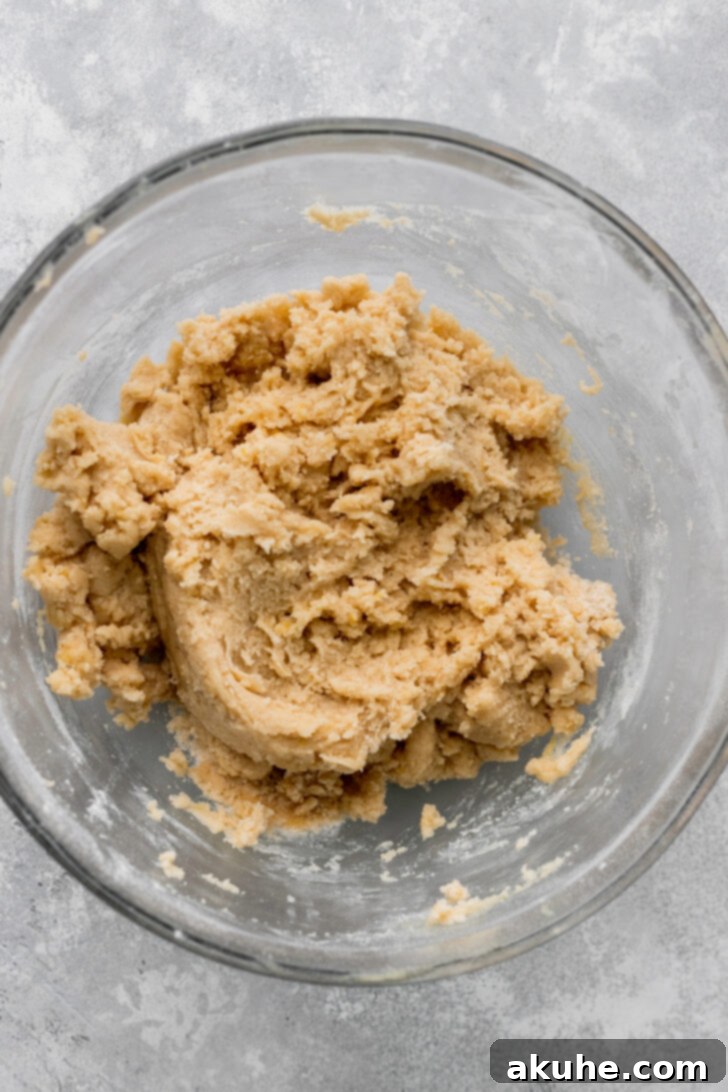 Dry ingredients (flour, baking powder, baking soda, salt) just added to the wet mixture in a glass bowl, before being fully combined.