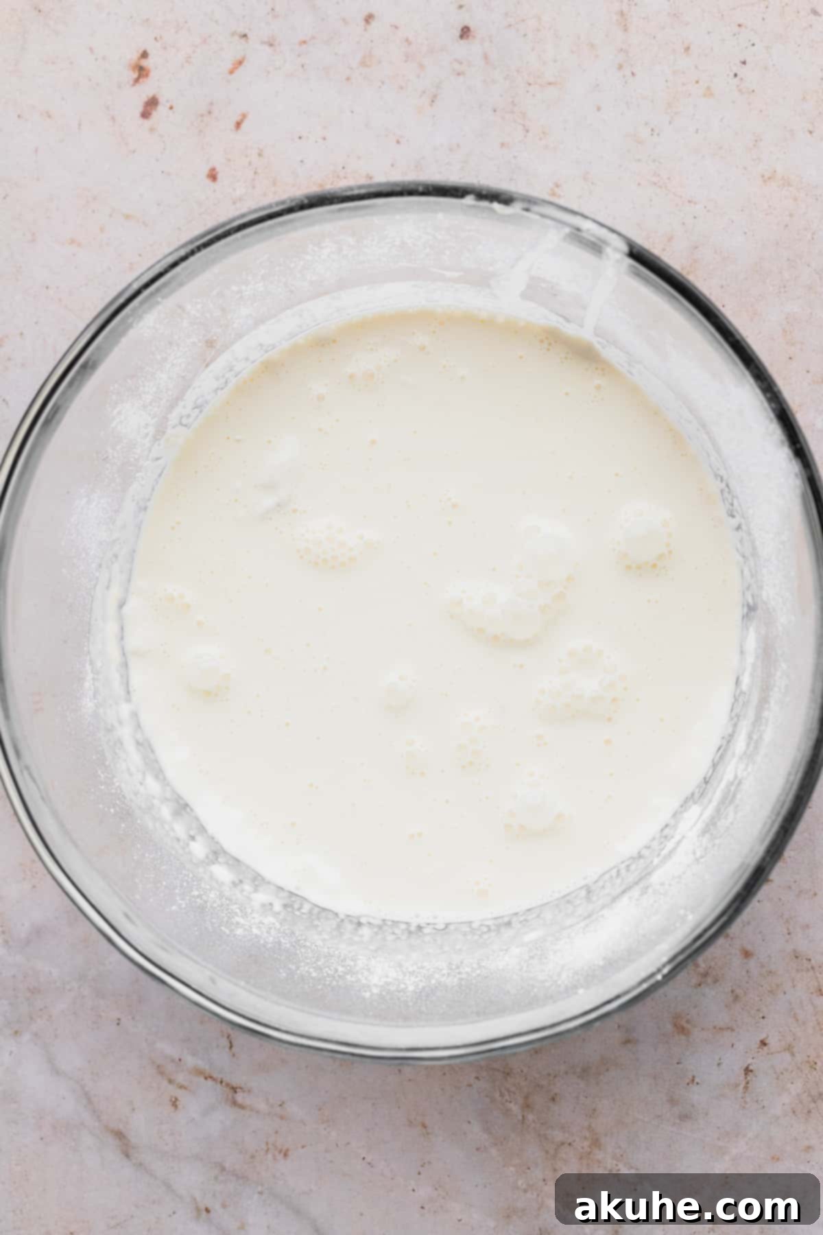 Heavenly Sweet Cream Pancakes 4 The process of pouring the whisked wet ingredients into the bowl of dry ingredients for sweet cream pancakes.