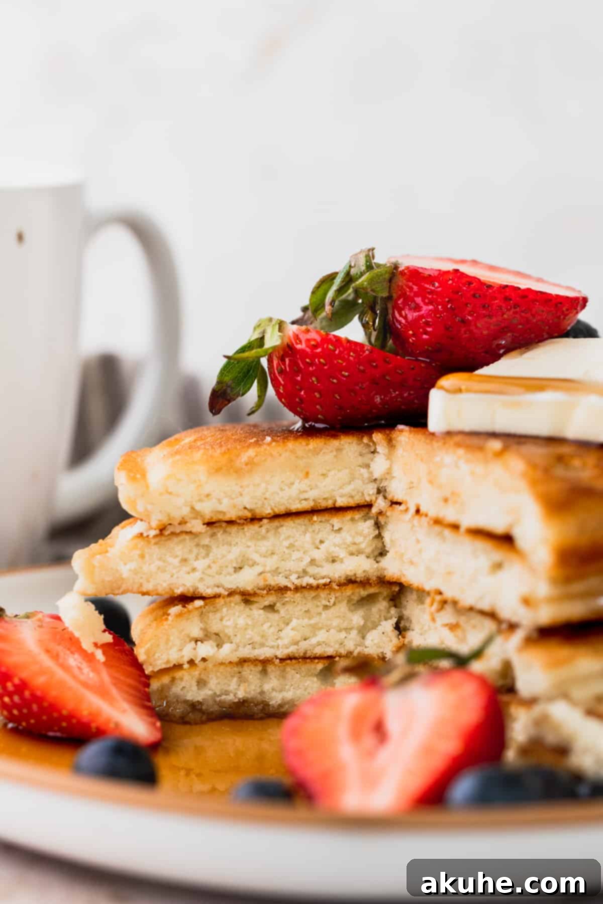 Heavenly Sweet Cream Pancakes 9 A stack of sweet cream pancakes cut in half, revealing the incredibly fluffy and airy interior texture.