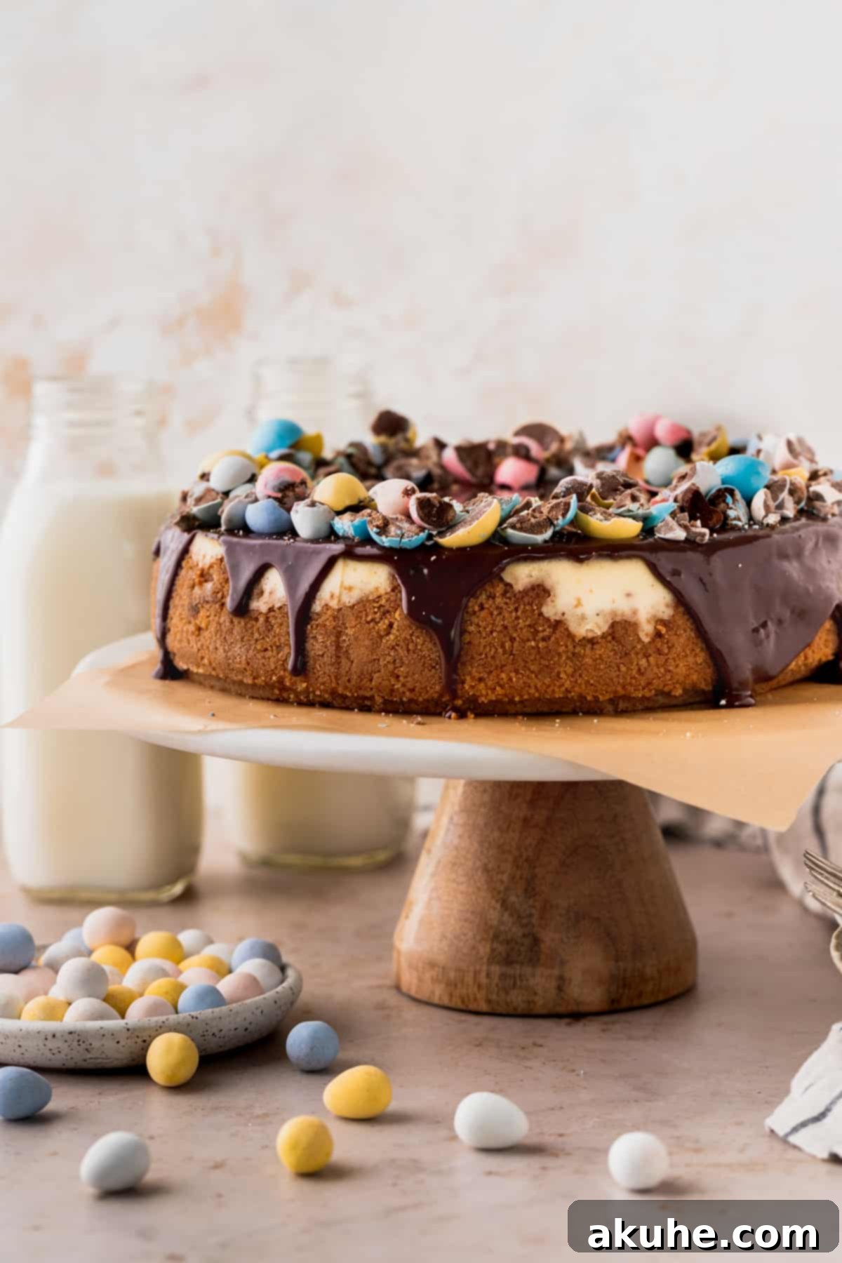 Whimsical Easter Egg Cheesecake 2 Easter egg cheesecake on a cake stand surrounding by mini eggs.