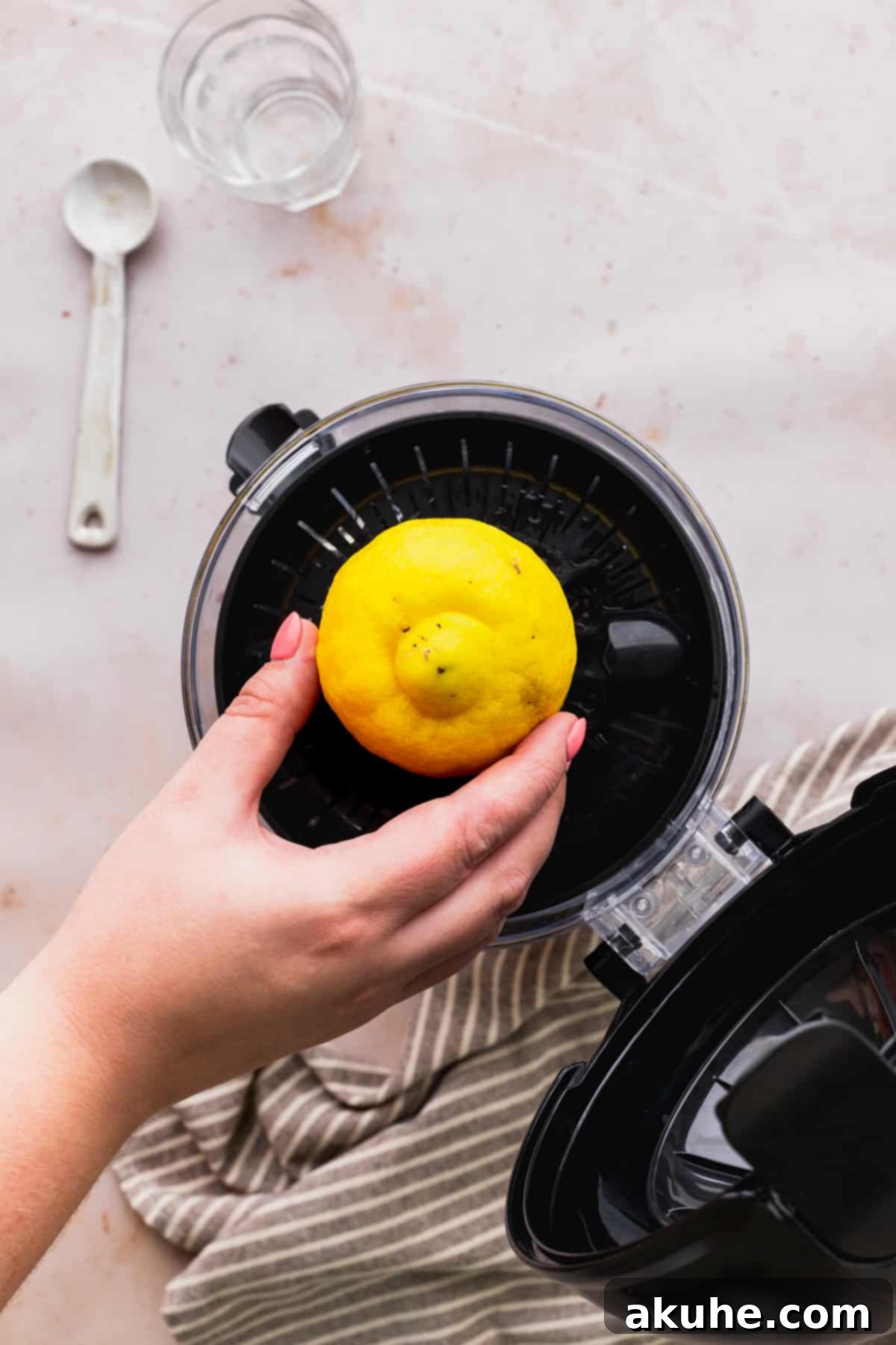 Decadent Lemon White Chocolate Bliss 4 A half lemon being placed onto the reamer of a juicer, ready for effortless juice extraction.