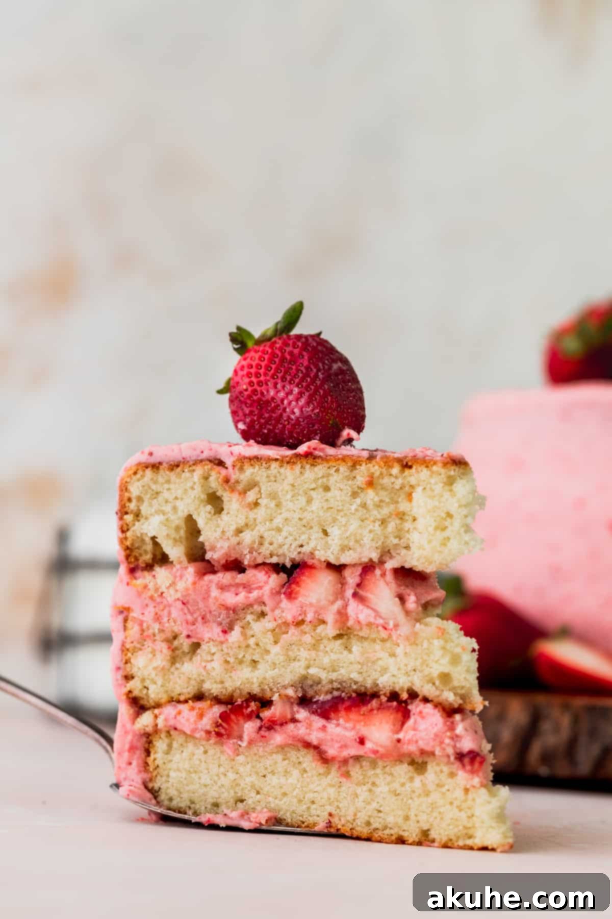 Sweet Strawberry Vanilla Dream 12 One slice of strawberry vanilla cake on a pie server, ready to be placed on a plate.