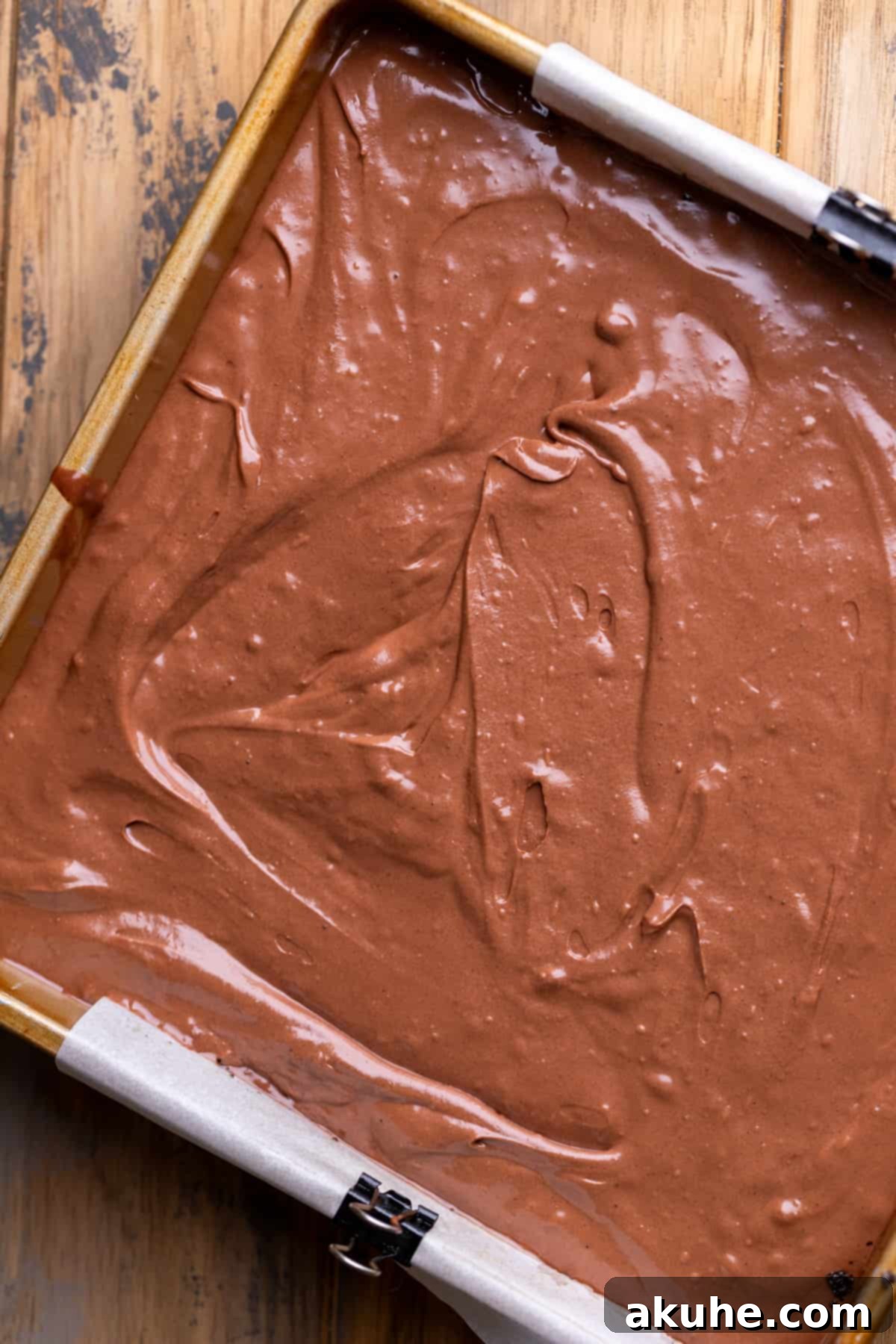 Decadent Chocolate Cheesecake Squares 6 Unbaked chocolate cheesecake batter evenly spread over the Oreo crust in a square baking pan, ready for the oven.