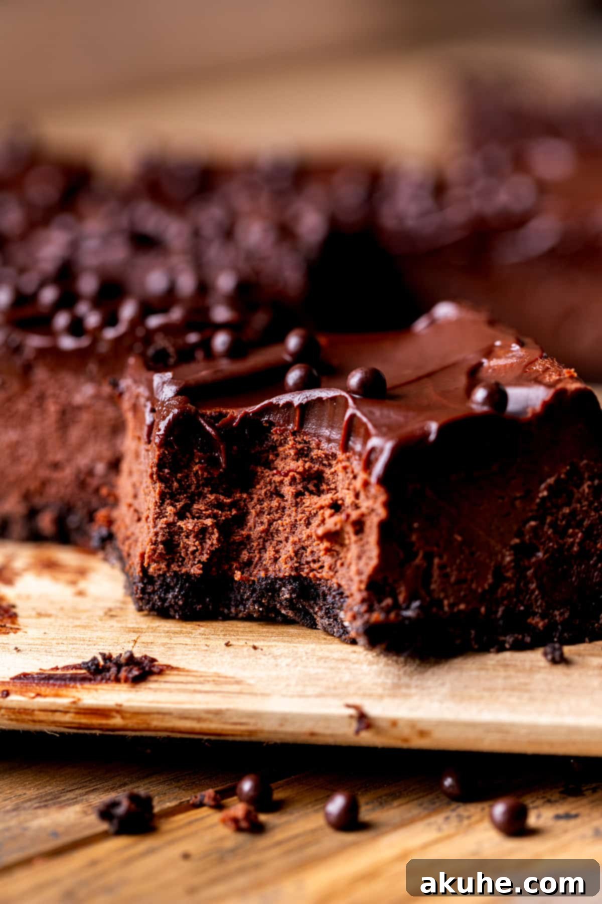 Decadent Chocolate Cheesecake Squares 9 A close-up of a chocolate cheesecake bar with a bite taken out, showing the creamy texture and rich chocolate layers.
