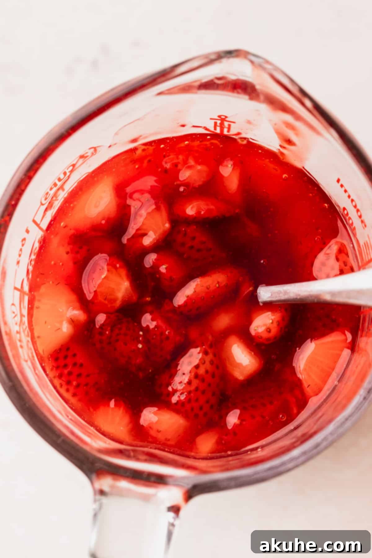 Top view of strawberry sauce in a glass measuring cup.
