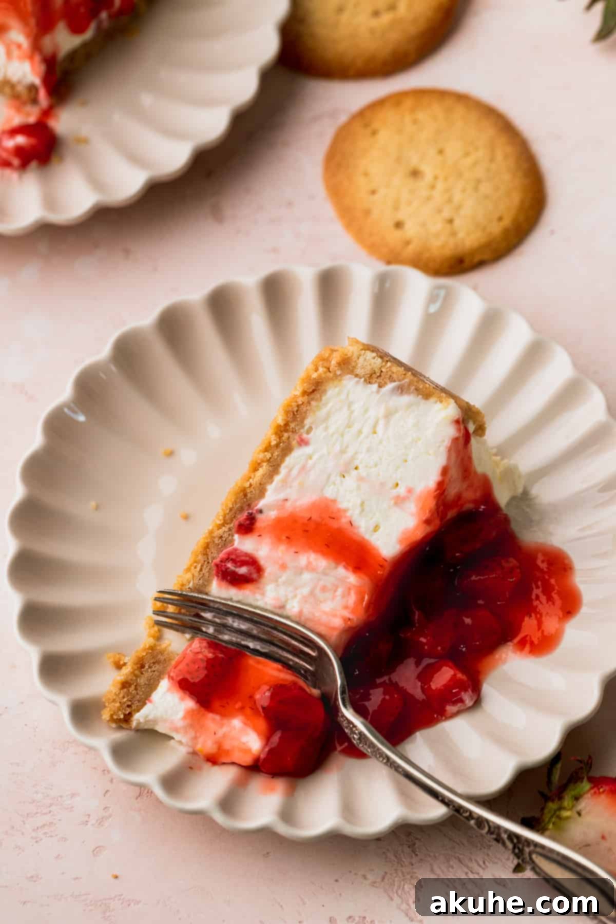 Slice of cheesecake on its side with a fork inserted on a plate.