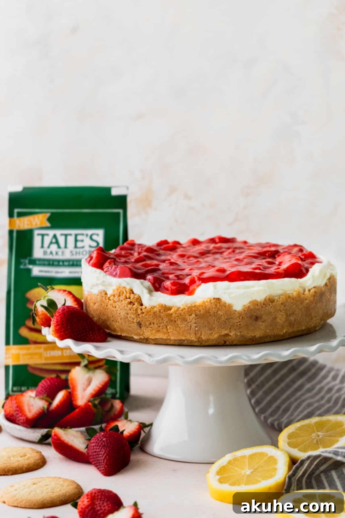 Lemon cheesecake with strawberry sauce on a cake stand.