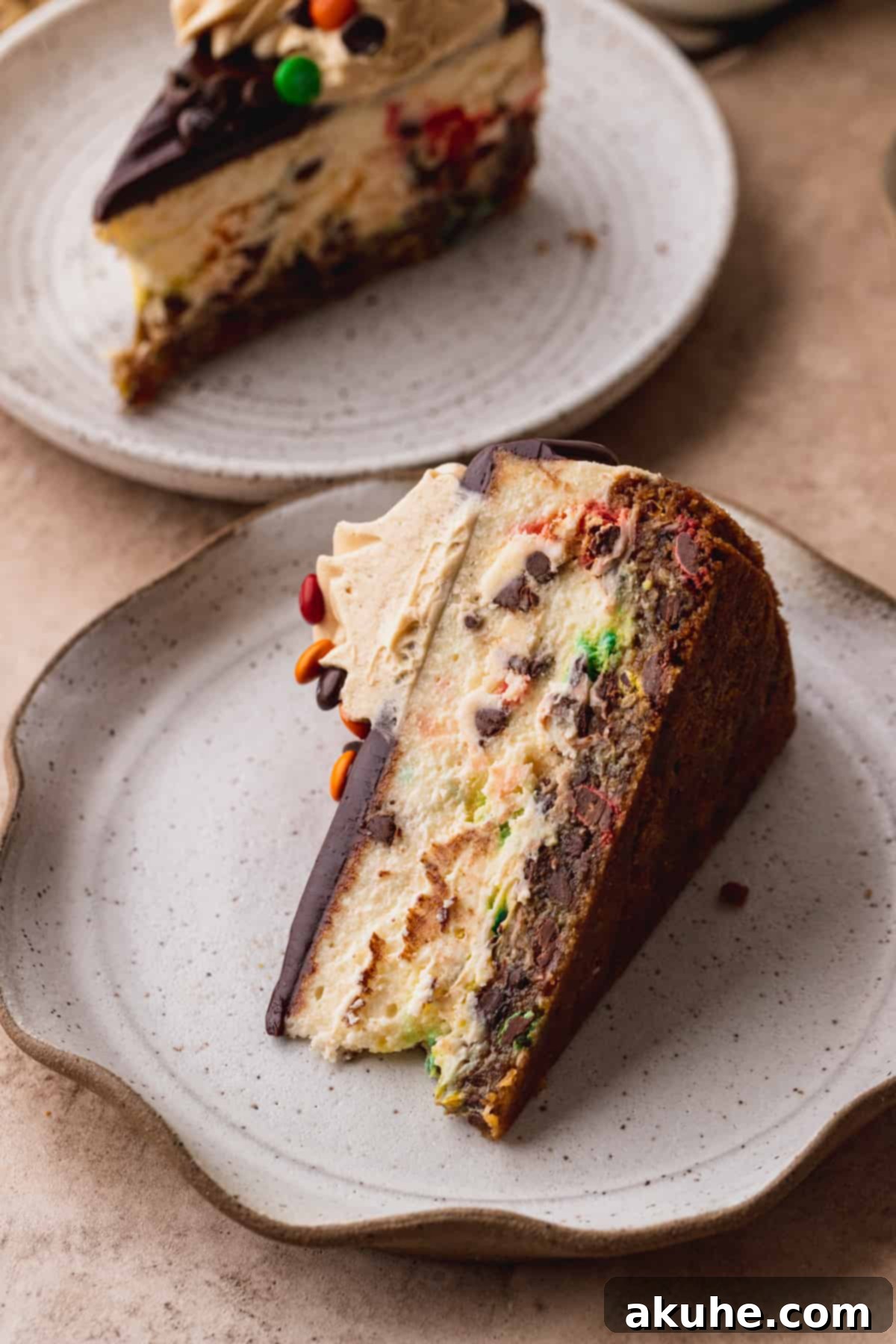 A perfectly portioned slice of Monster Cookie Cheesecake on a white plate, revealing its intricate layers and colorful filling.