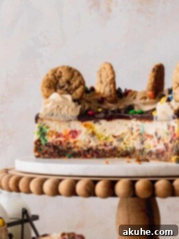 Monster cookie cheesecake cut in half on a cake stand.