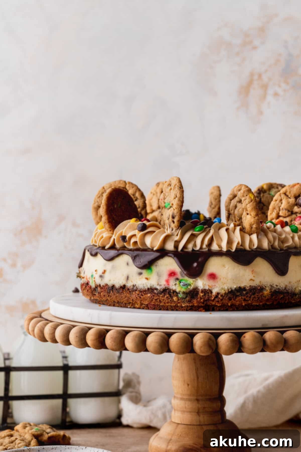 A beautifully baked Monster Cookie Cheesecake resting on a pristine cake stand, ready for its decadent toppings.