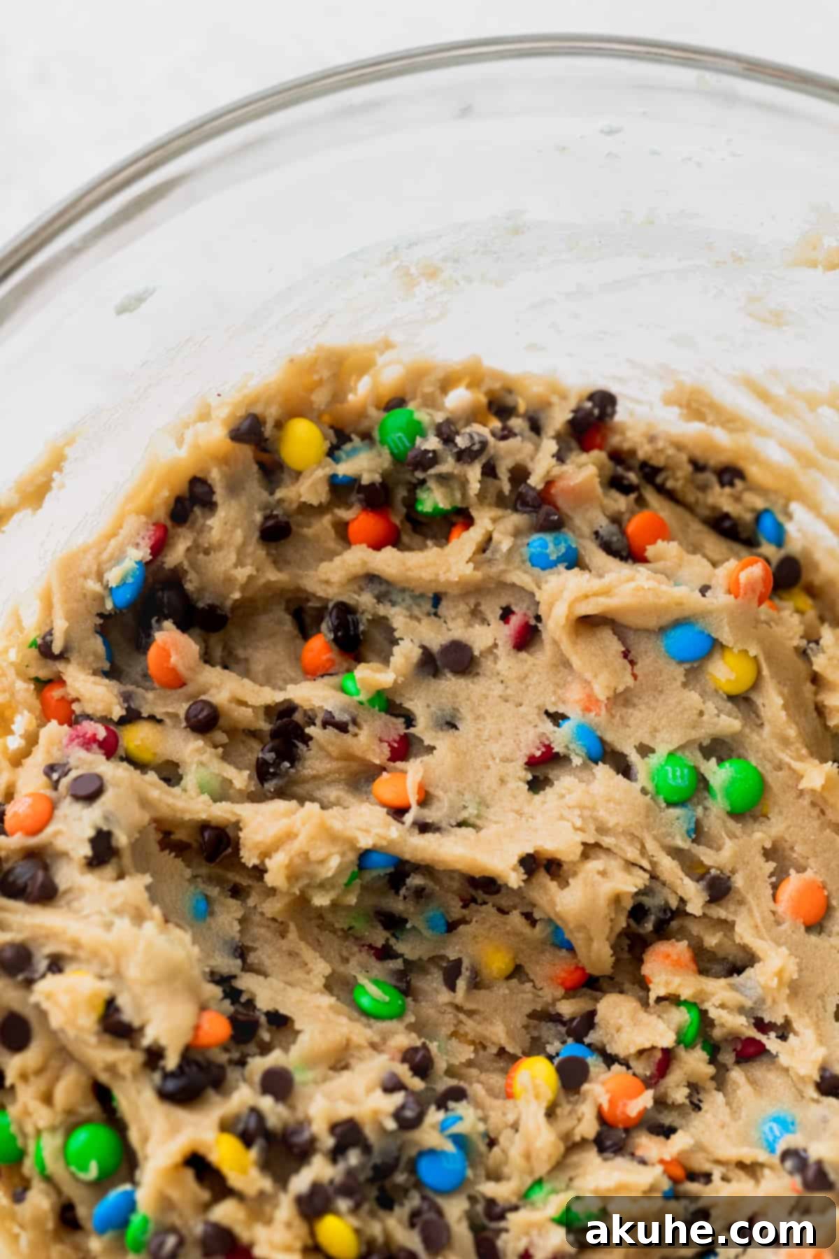 A bowl filled with freshly prepared cookie dough, awaiting scooping.
