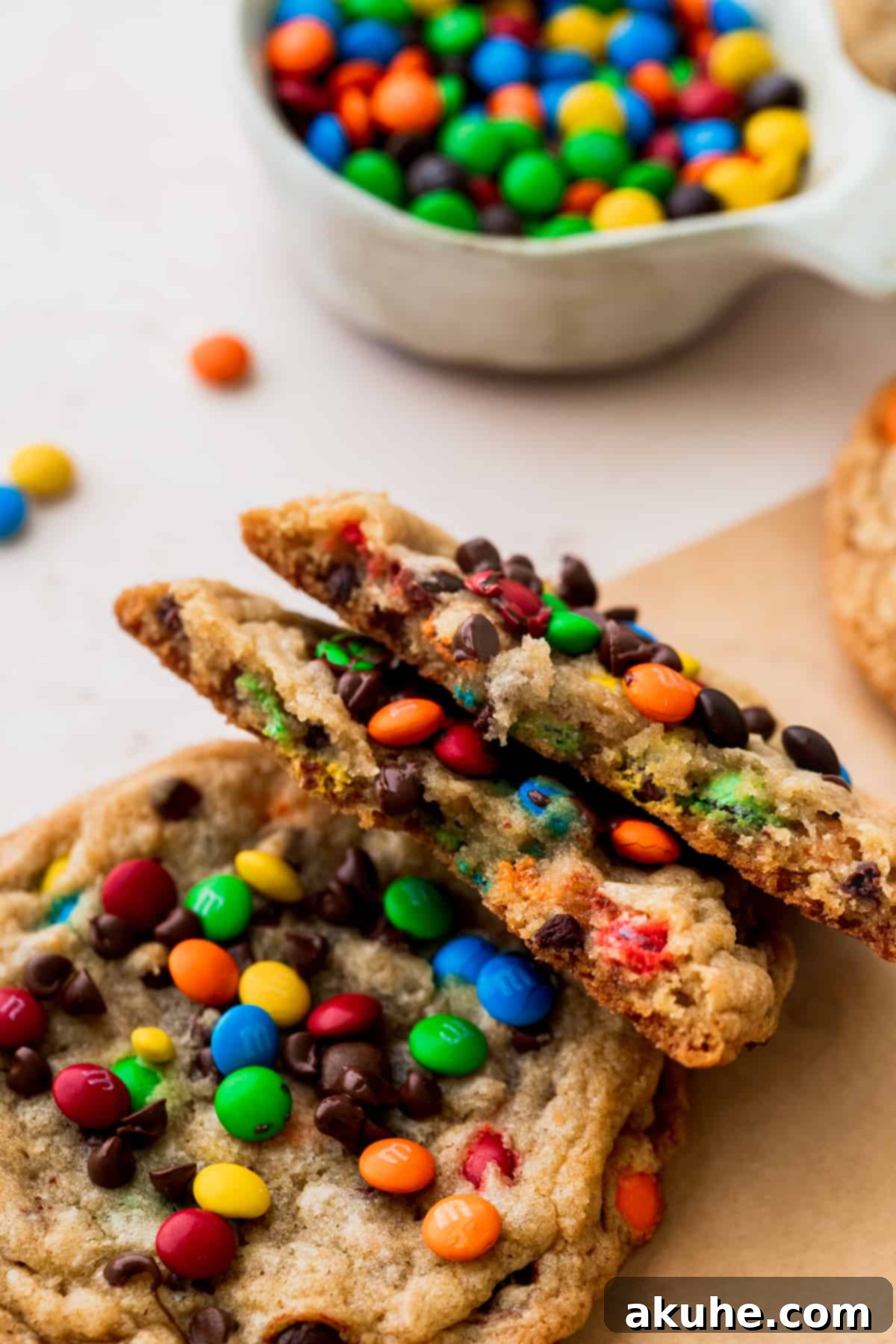 One mini M&M cookie perfectly split in half, showcasing its rich, chewy interior and an abundance of colorful M&Ms and chocolate chips.