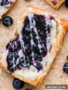 Close up of blueberry danish on parchment paper.