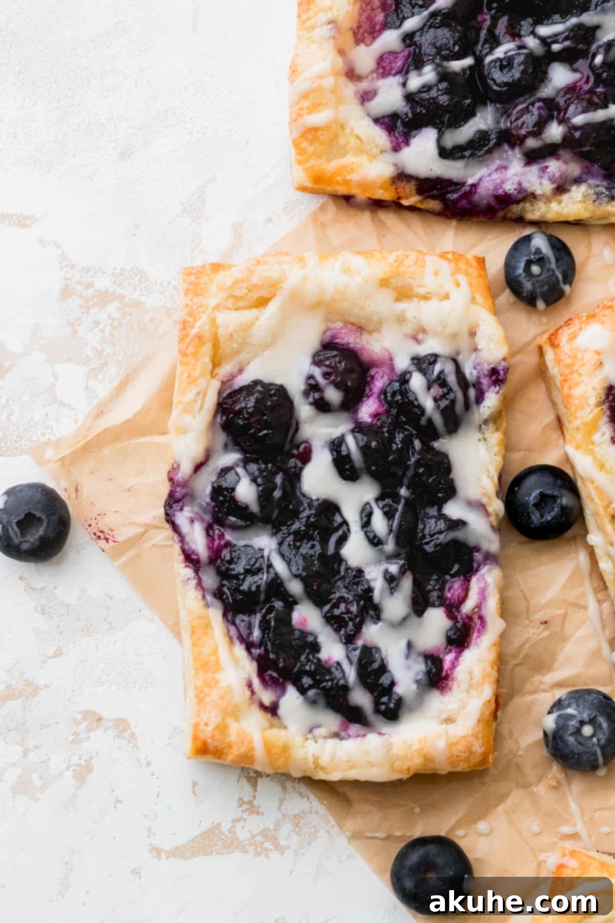 One blueberry danish with vanilla icing on top, ready to be enjoyed.