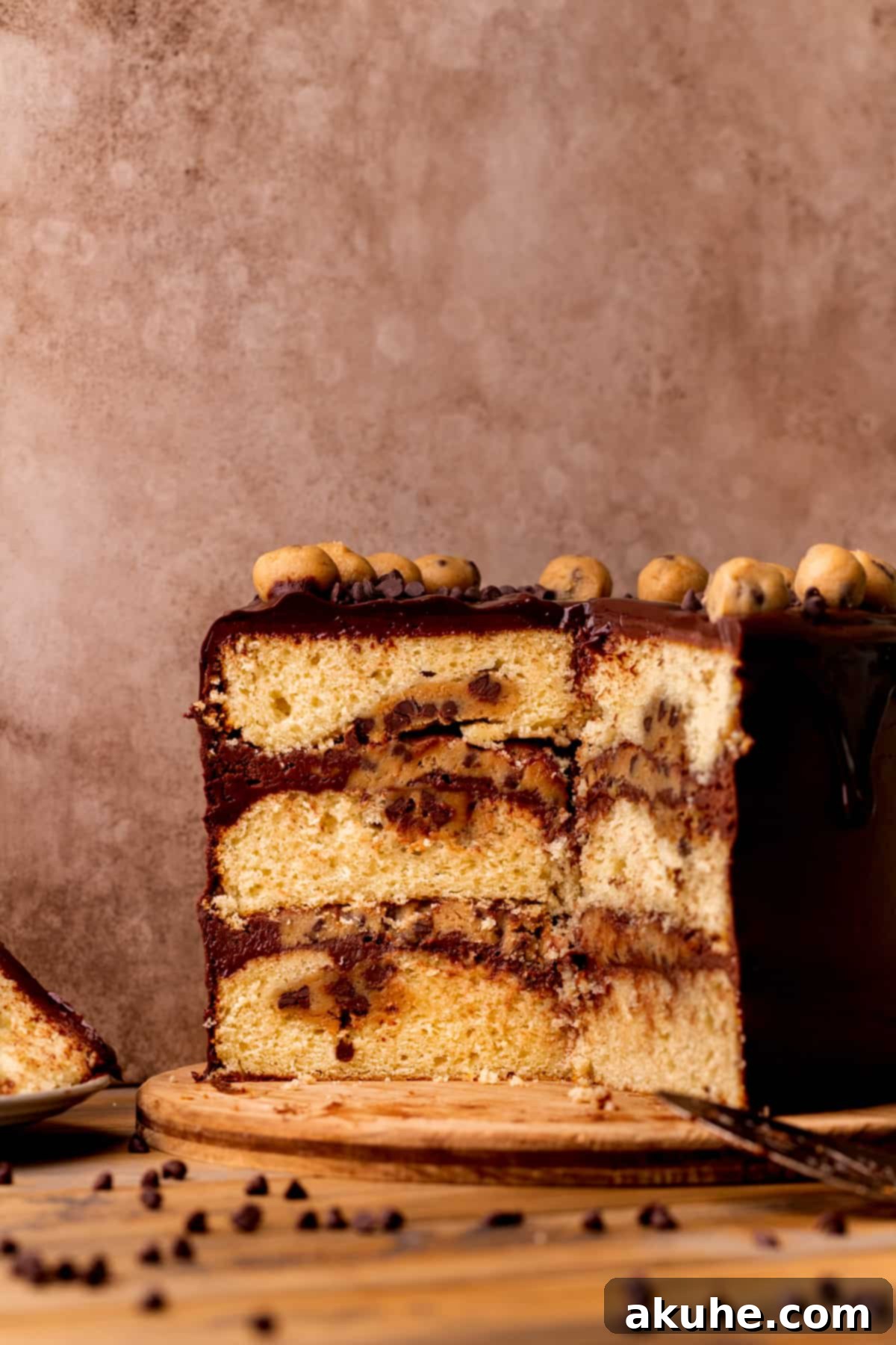 Decadent Cookie Dough Cake 2 A slice of our decadent Cookie Dough Dream Cake, revealing its moist vanilla layers, rich chocolate cream cheese frosting, and generous edible cookie dough filling.