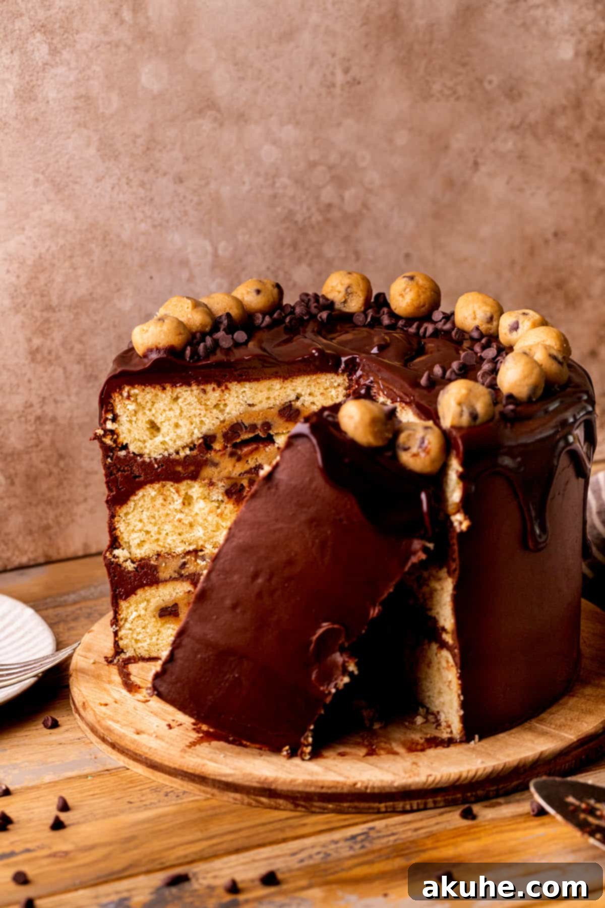 Decadent Cookie Dough Cake 13 A beautiful slice of Cookie Dough Dream Cake resting on its side next to the full cake, highlighting its delightful layers and textures.