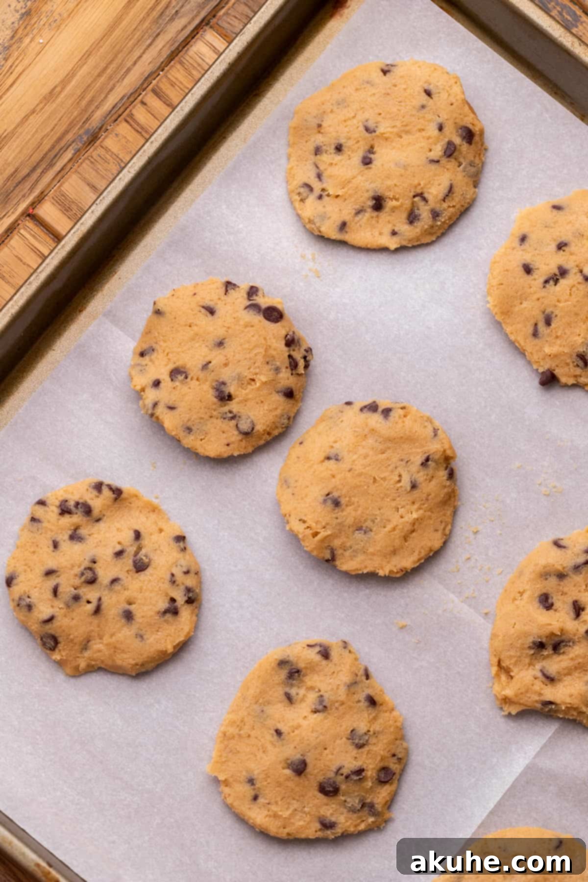Decadent Cookie Dough Cake 5 Edible cookie dough flattened into discs and arranged on a parchment-lined cookie sheet, ready for chilling.
