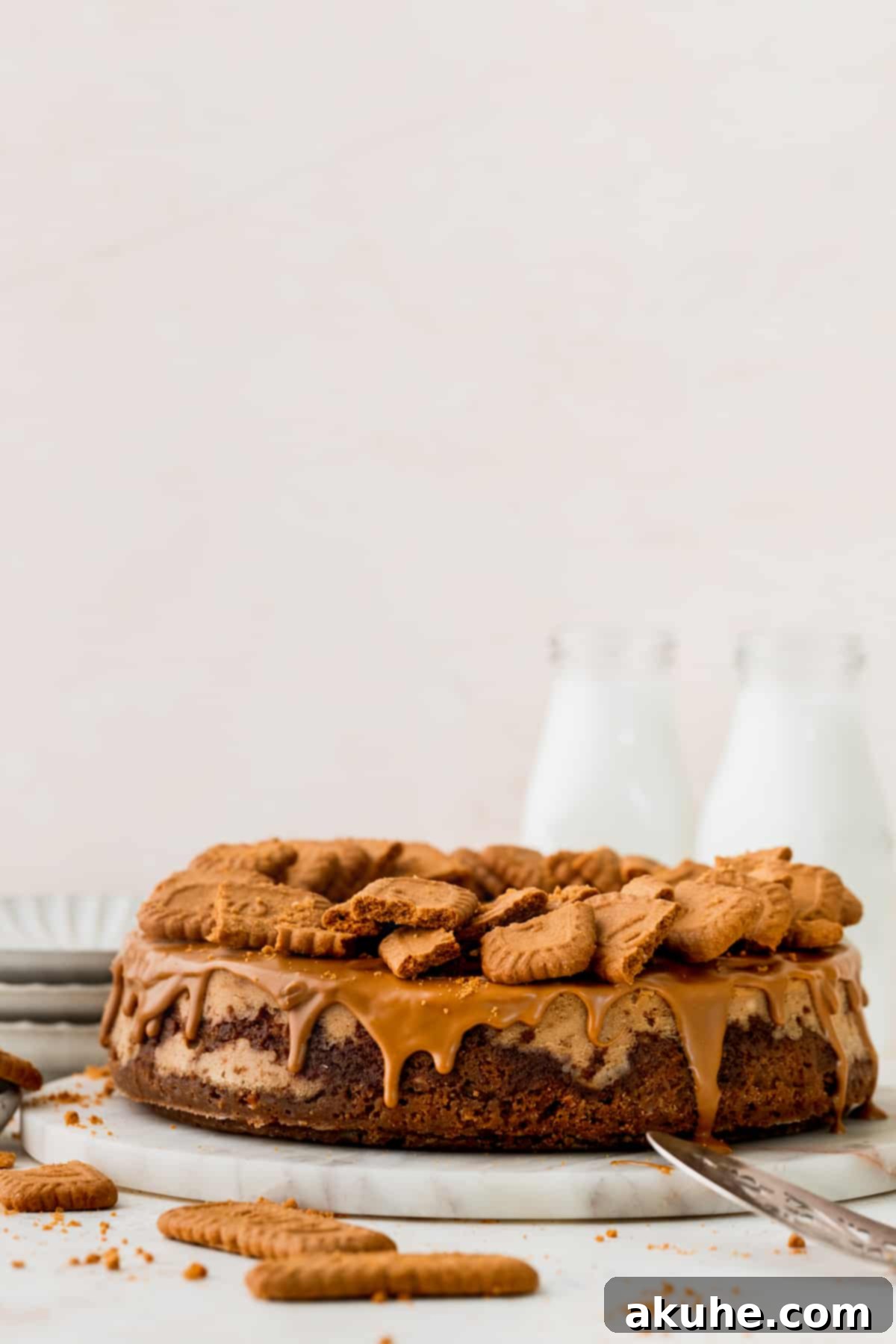 The Ultimate Biscoff Cheesecake 2 A stunning Biscoff cheesecake artfully placed on a elegant marble board, showcasing its rich layers and tempting topping.