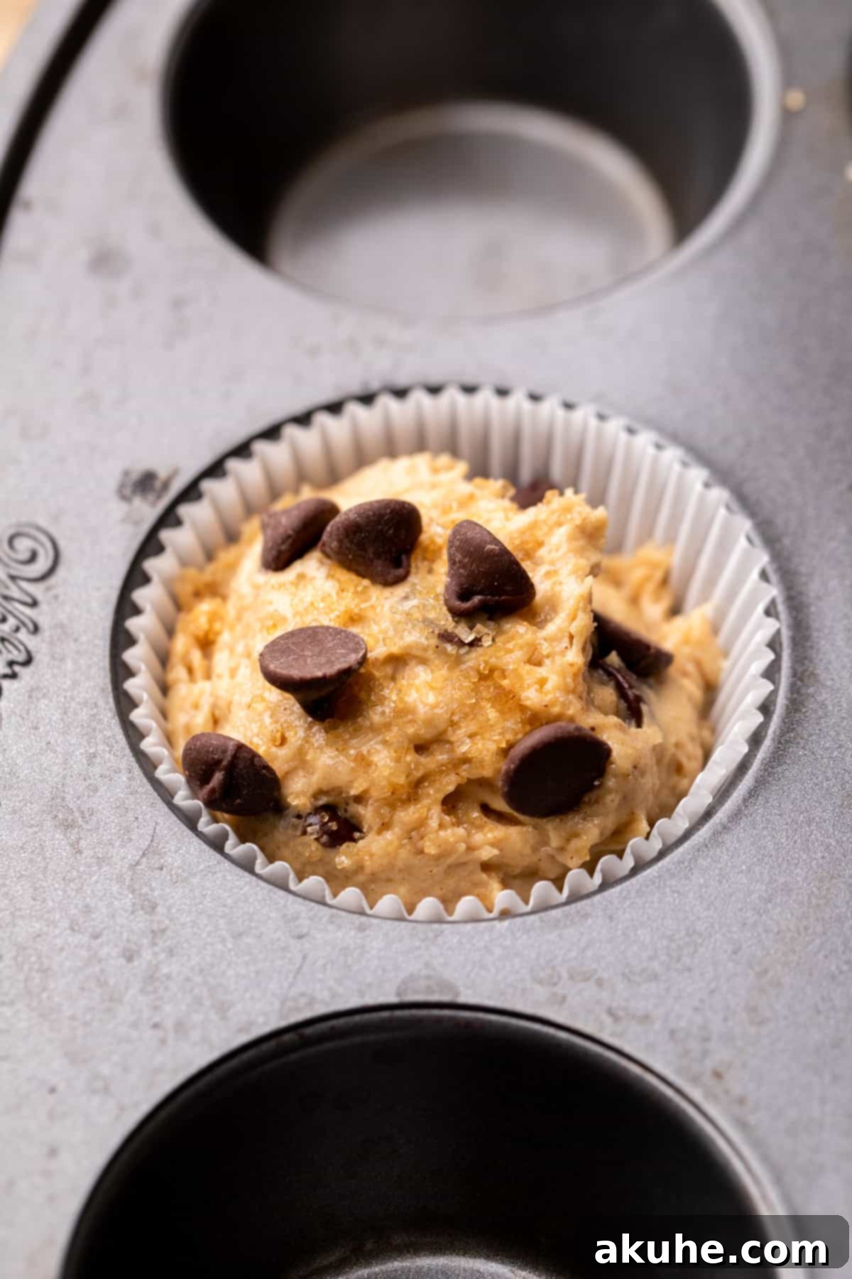 Ultimate Peanut Butter Banana Muffins 6 Muffin batter in a muffin pan.