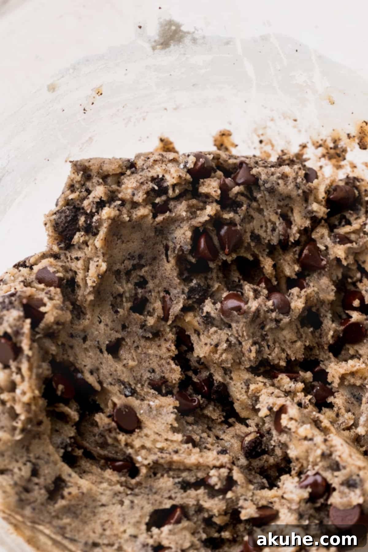 Ultimate Oreo Brookie Indulgence 6 Finished Oreo chocolate chip cookie dough in a clear glass bowl, ready for swirling.