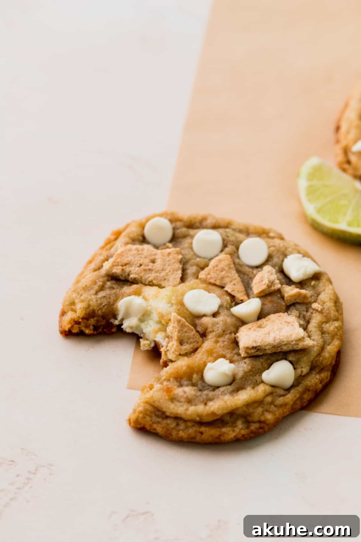 Zesty Key Lime Cookies 13 A delectable Key Lime Cookie with a single bite missing, highlighting its chewy texture and creamy filling.
