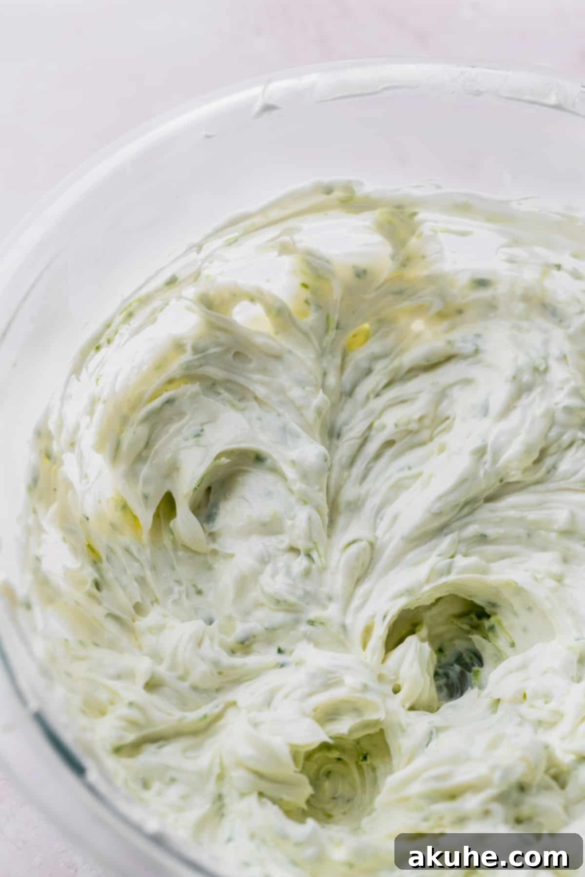 Zesty Key Lime Cookies 4 Key lime cheesecake batter in a clear glass bowl, showcasing its smooth texture.