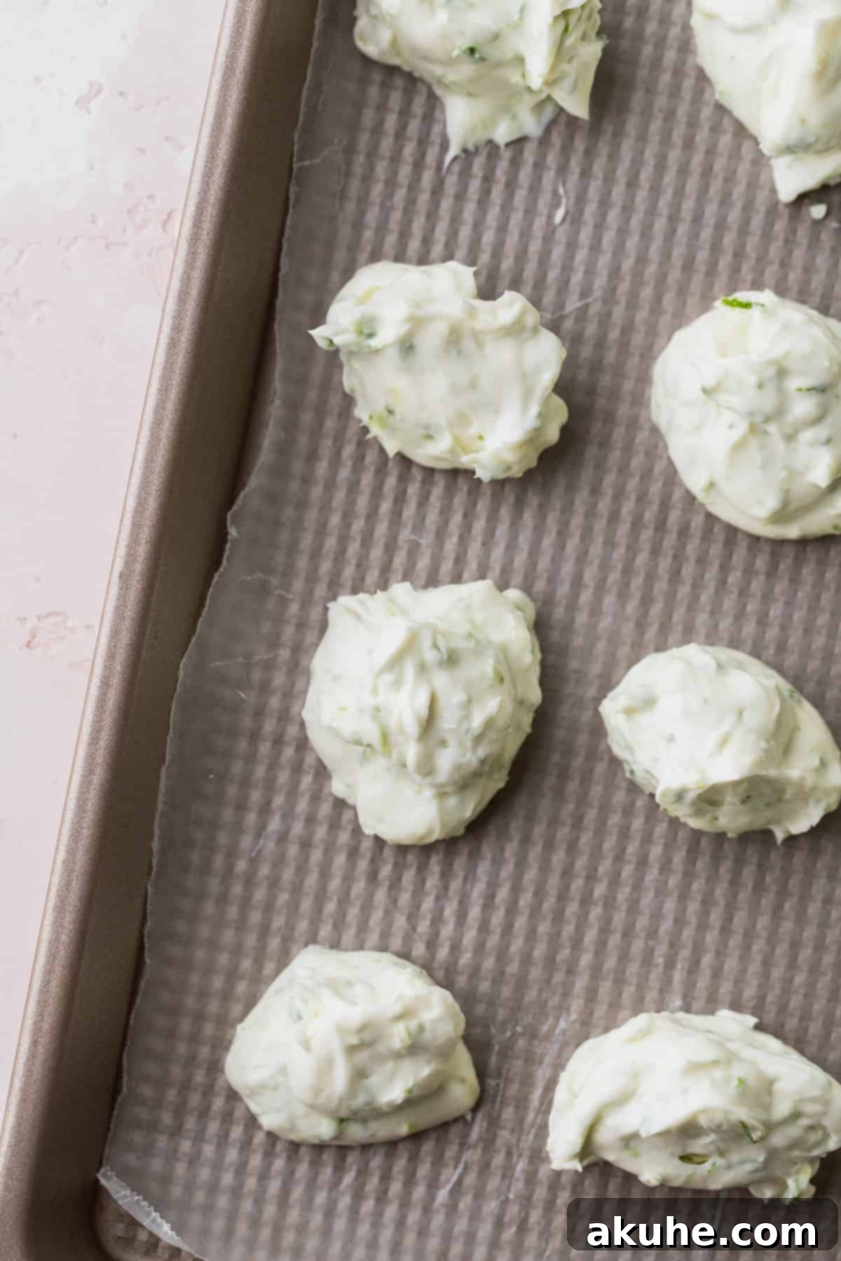 Zesty Key Lime Cookies 5 Neatly dolloped portions of key lime cheesecake filling arranged on a cookie sheet lined with wax paper, ready for freezing.