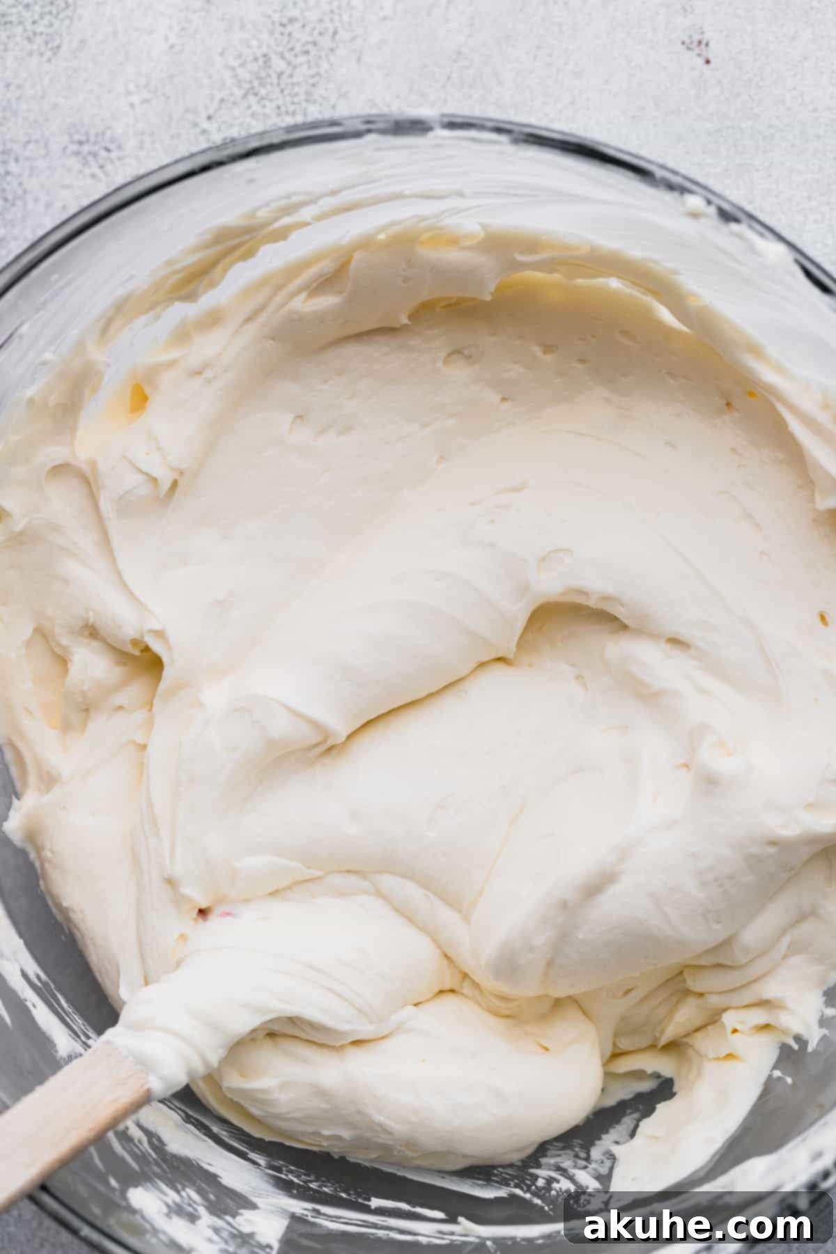 The smooth, creamy cheesecake batter filling a glass bowl, showcasing its rich and inviting texture before being poured into the crust.