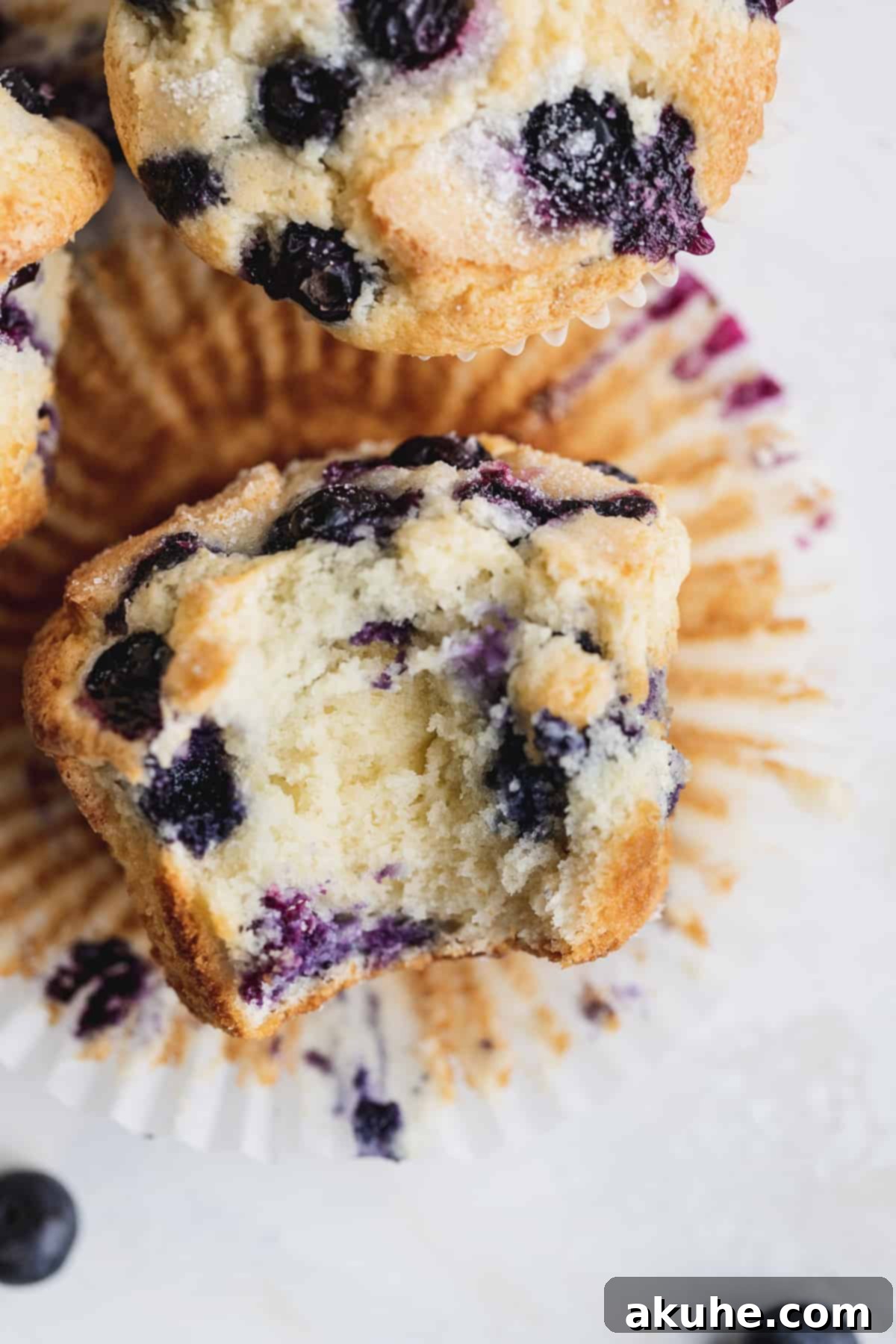 Giant Bakery Style Blueberry Muffins 9 Top view of a jumbo blueberry muffin with a bite taken out, showing the moist crumb and blueberries.