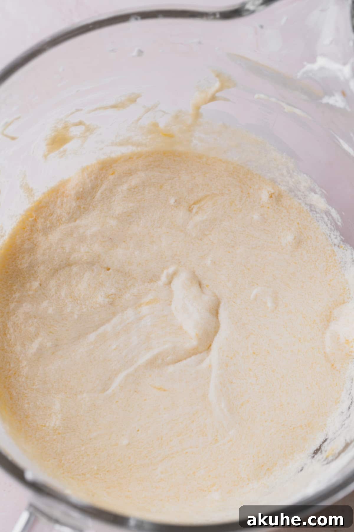 A large mixing bowl containing the perfectly creamed wet ingredients, ready for the next step of the vanilla raspberry cake preparation.