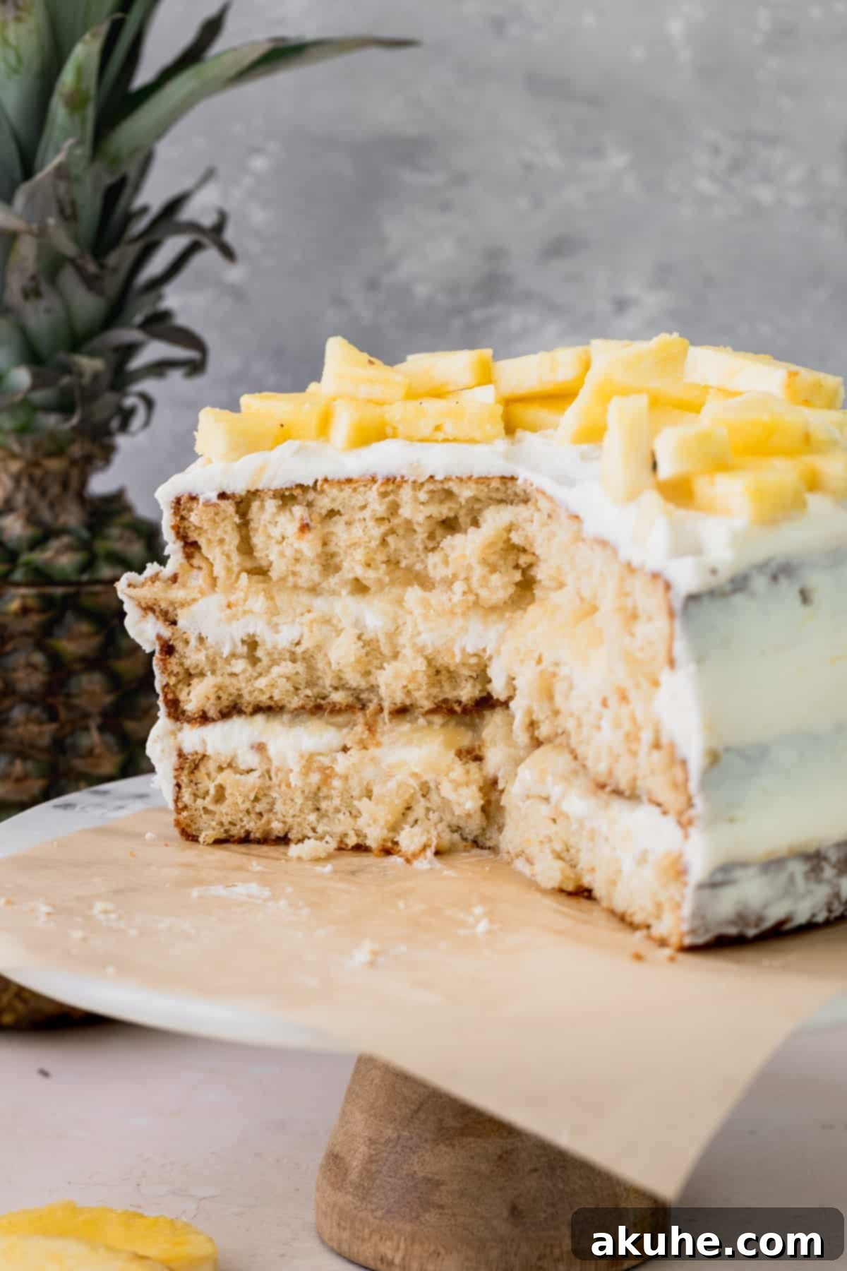 Tropical Pineapple Delight 2 Pineapple sunshine cake cut into on a cake stand, showcasing its vibrant layers.