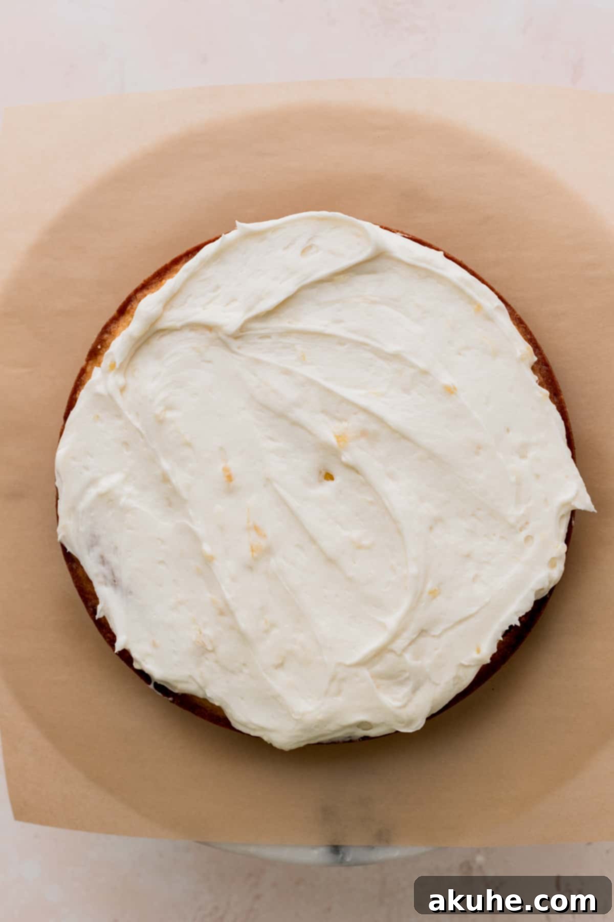 Tropical Pineapple Delight 11 A layer of pineapple cream cheese frosting spread evenly on a cake layer.