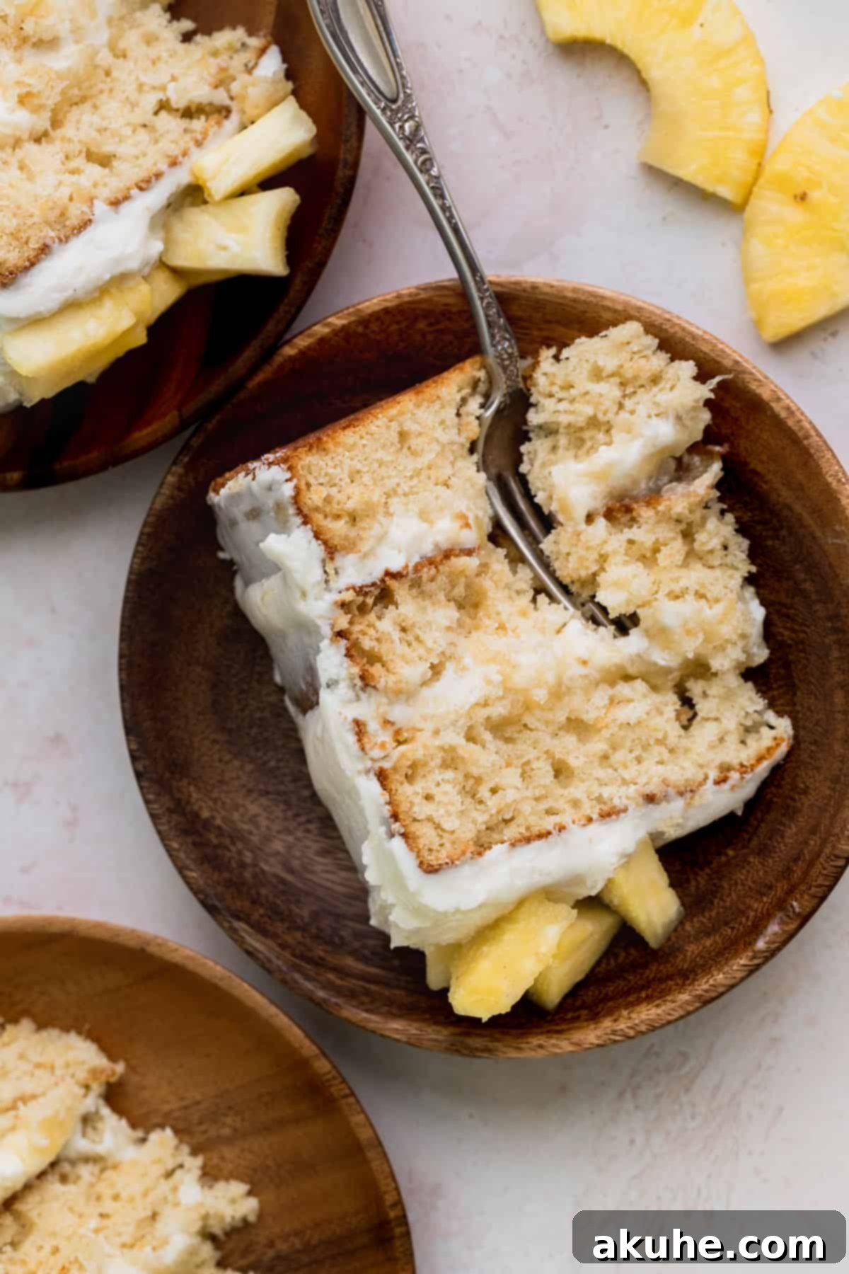 Tropical Pineapple Delight 14 Three perfectly presented slices of Pineapple Sunshine Cake on charming wooden plates.
