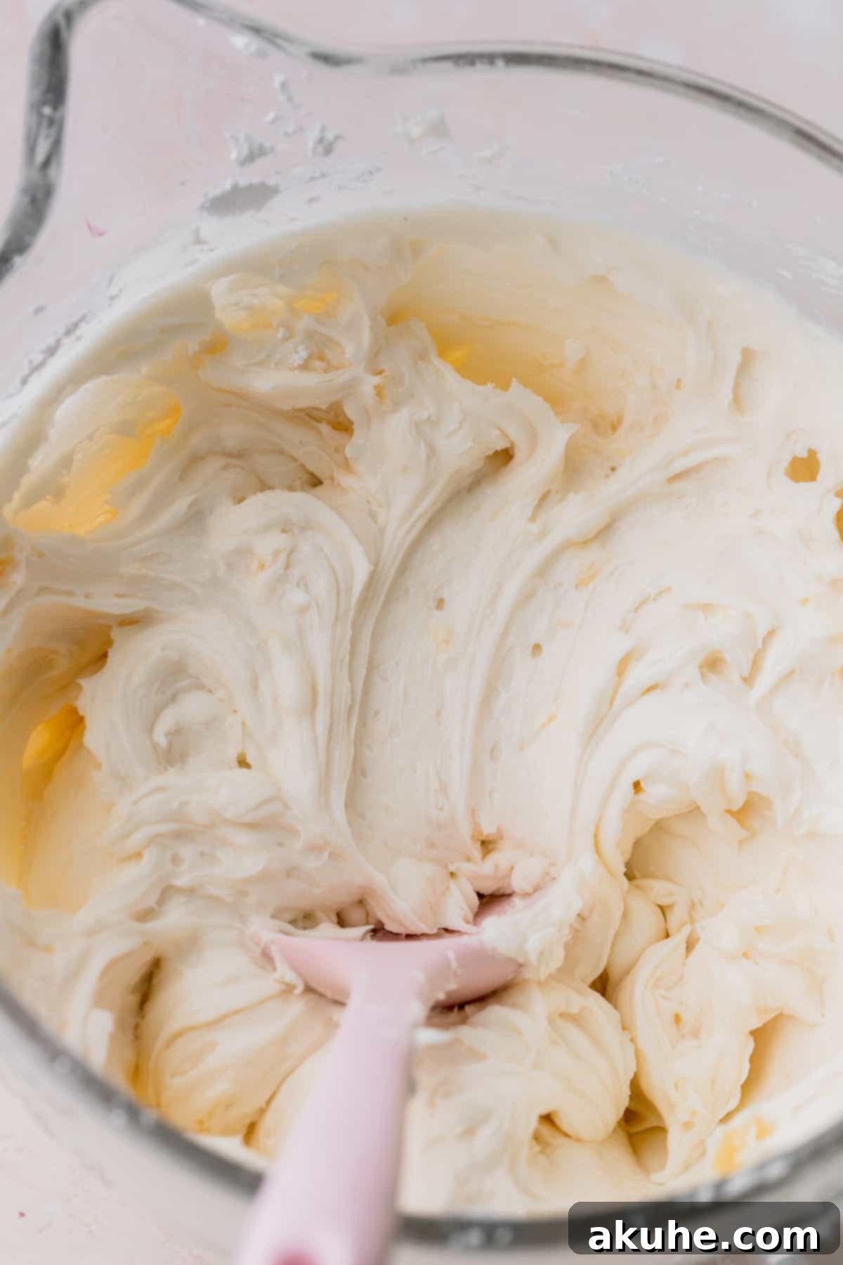 Tropical Pineapple Delight 10 Fluffy pineapple cream cheese frosting in a glass bowl.