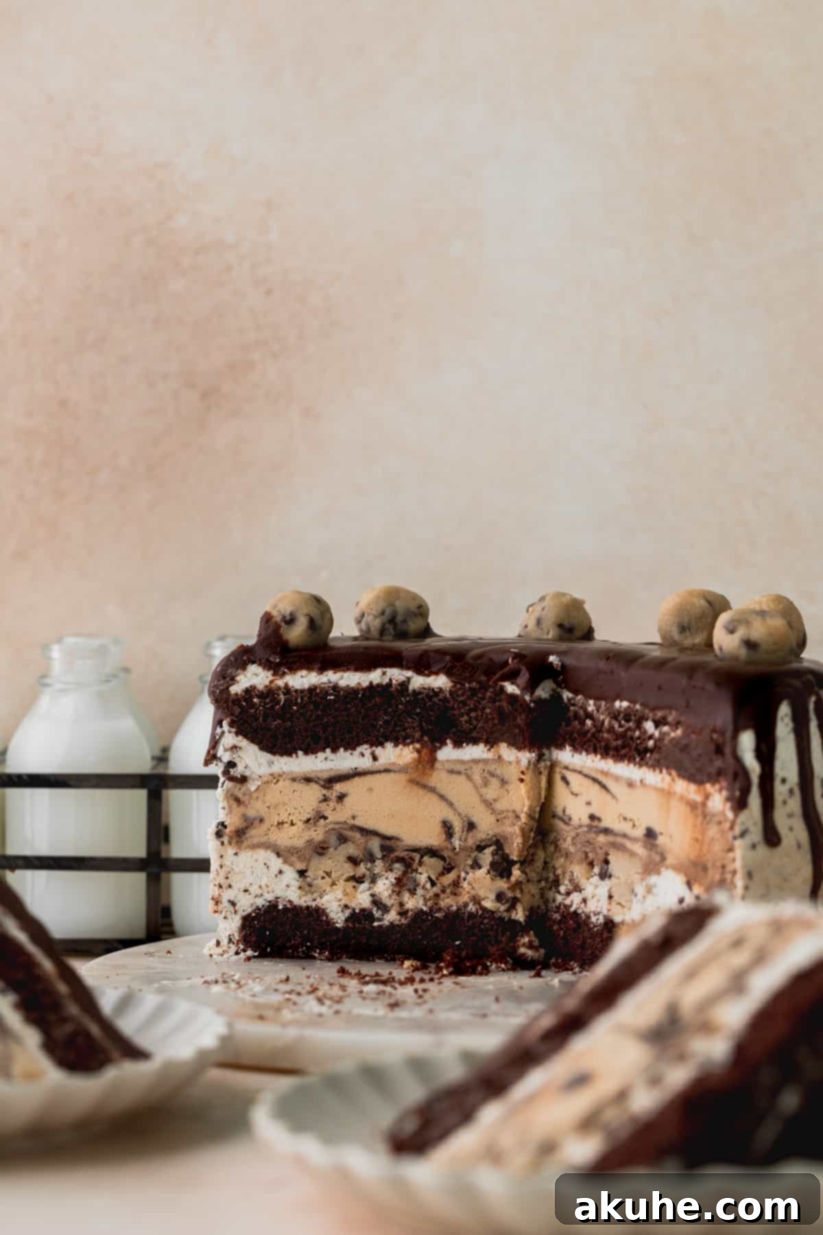 Ultimate Cookie Dough Ice Cream Cake 2 A perfectly sliced cookie dough ice cream cake, showing layers of chocolate cake, ice cream, and cookie dough, presented on a elegant marble board.