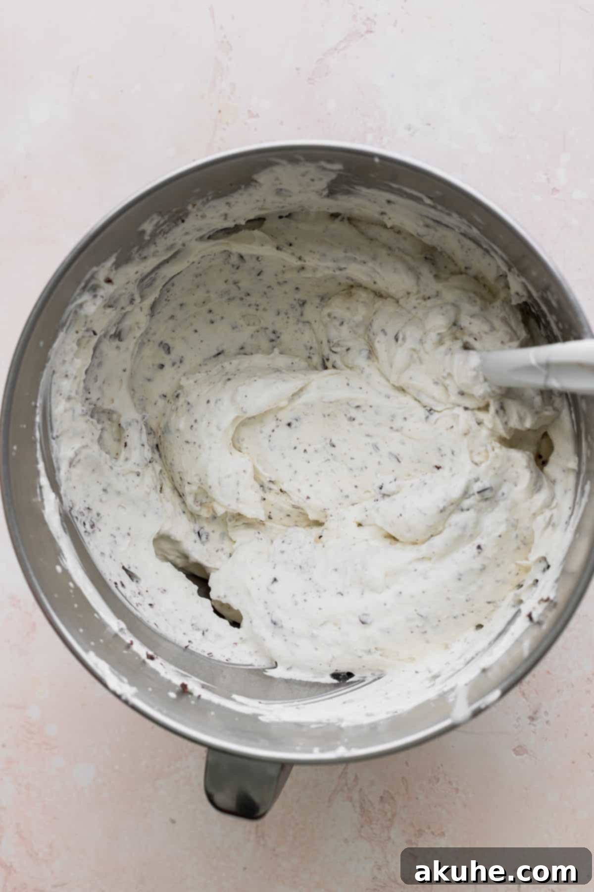 Ultimate Cookie Dough Ice Cream Cake 11 Fluffy, stable chocolate chunk whipped cream in a cold metal mixing bowl, ready for frosting.