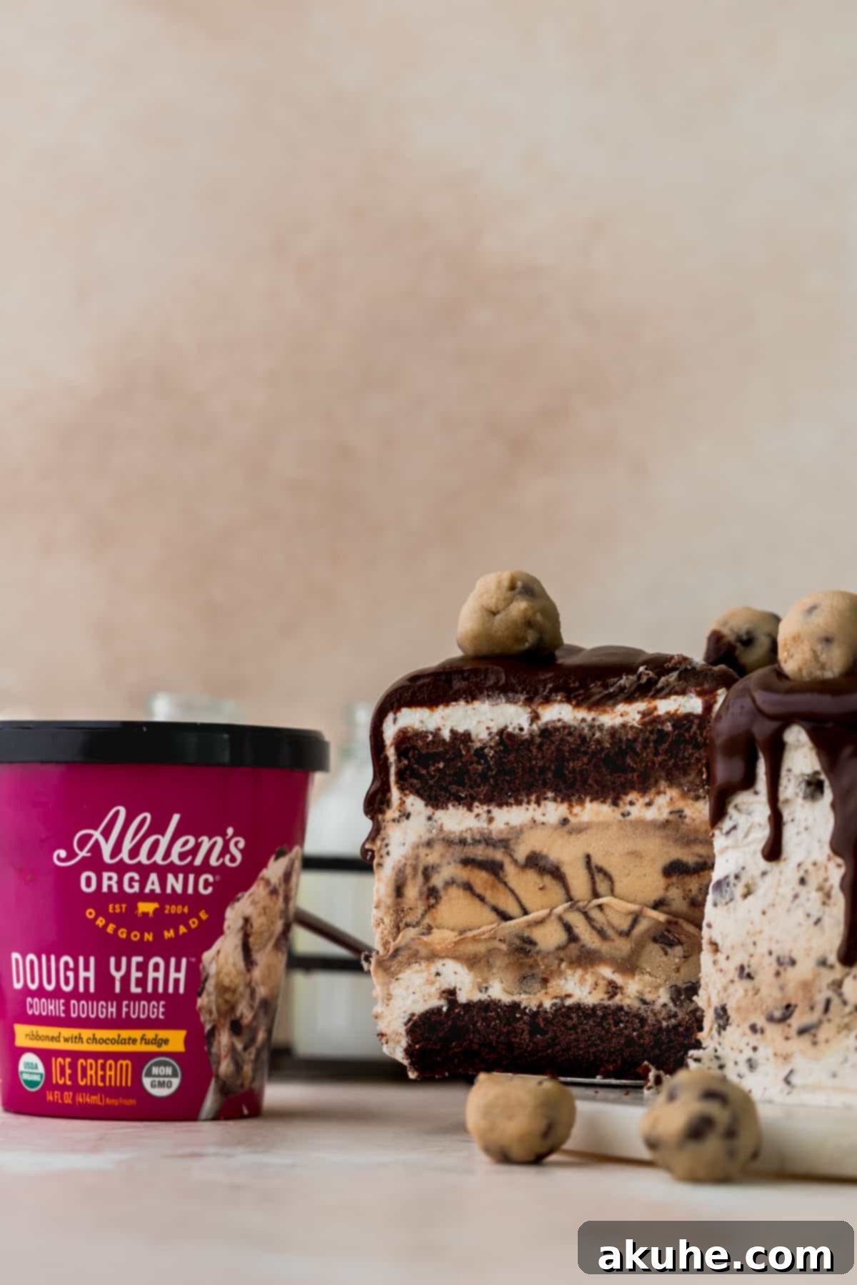 Ultimate Cookie Dough Ice Cream Cake 3 A hand taking a perfect slice out of the multi-layered cookie dough ice cream cake, showcasing all its components.