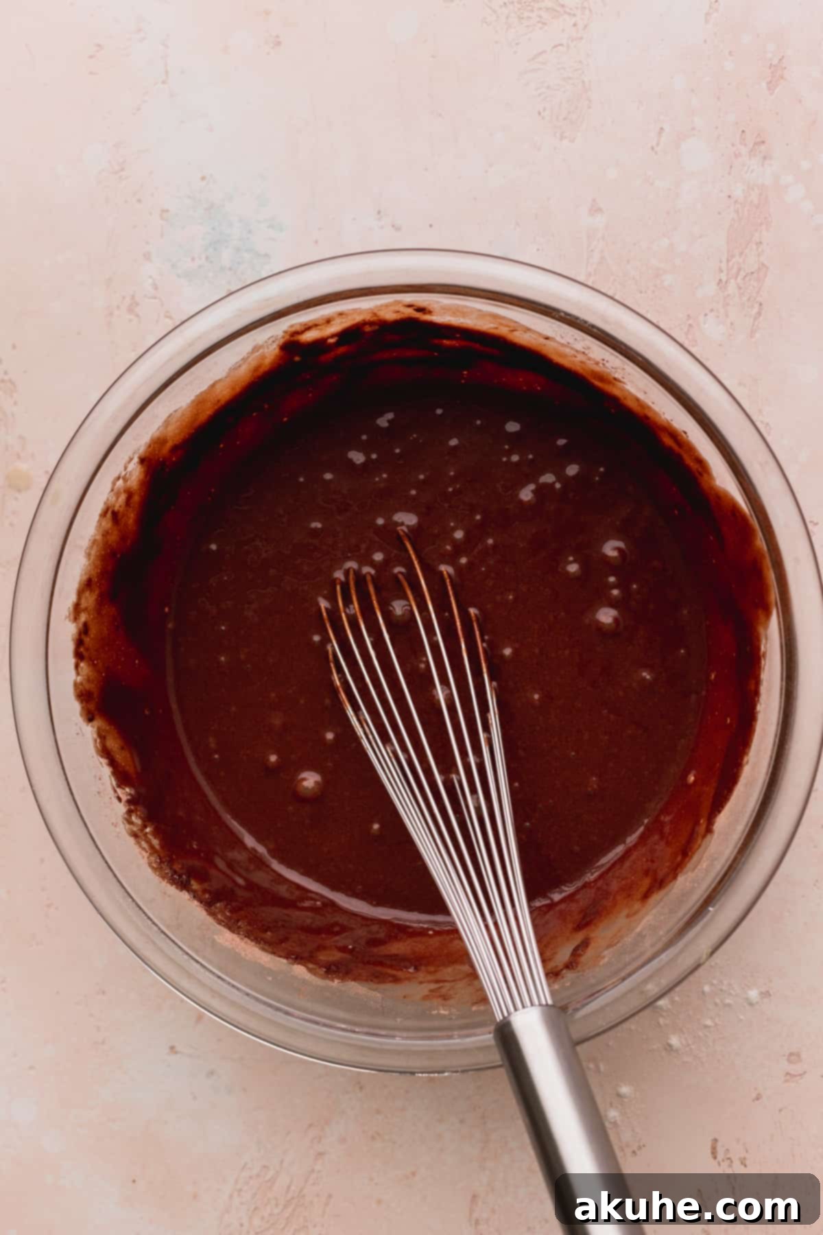 Ultimate Cookie Dough Ice Cream Cake 6 Smooth, rich chocolate cake batter resting in a clear glass bowl, ready for baking.